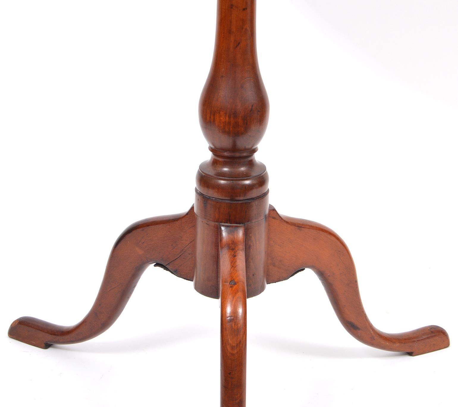 This great new England cherry candle stand features a round top above an oakwood structural support and a balluster turned column resting on three wide cabriole legs with pad feet.