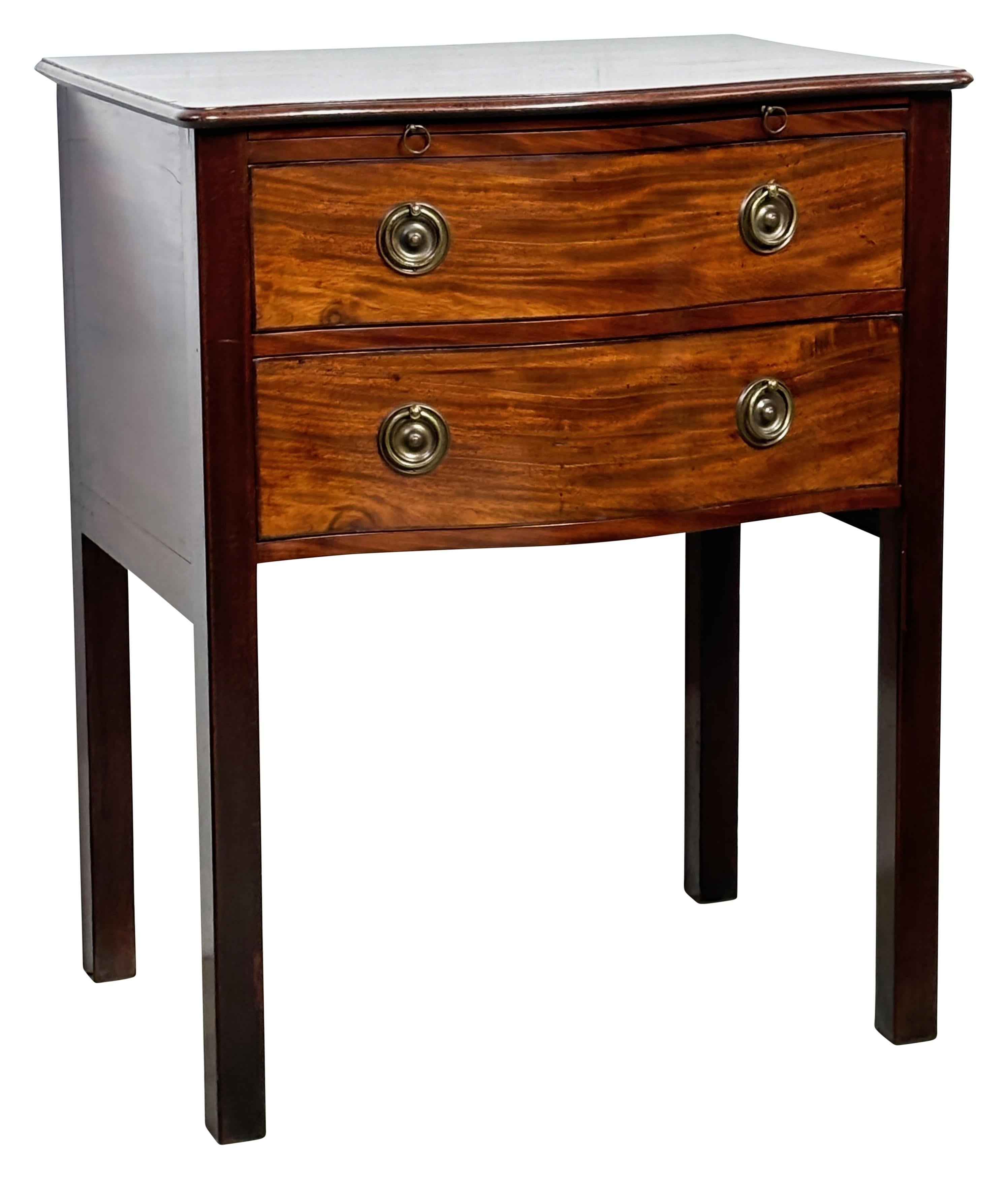 A solid mahogany bow front two drawer bedside / side table with pull out writing surface.
In unusually good condition with original brass hardware.
England George III period, circa 1820.