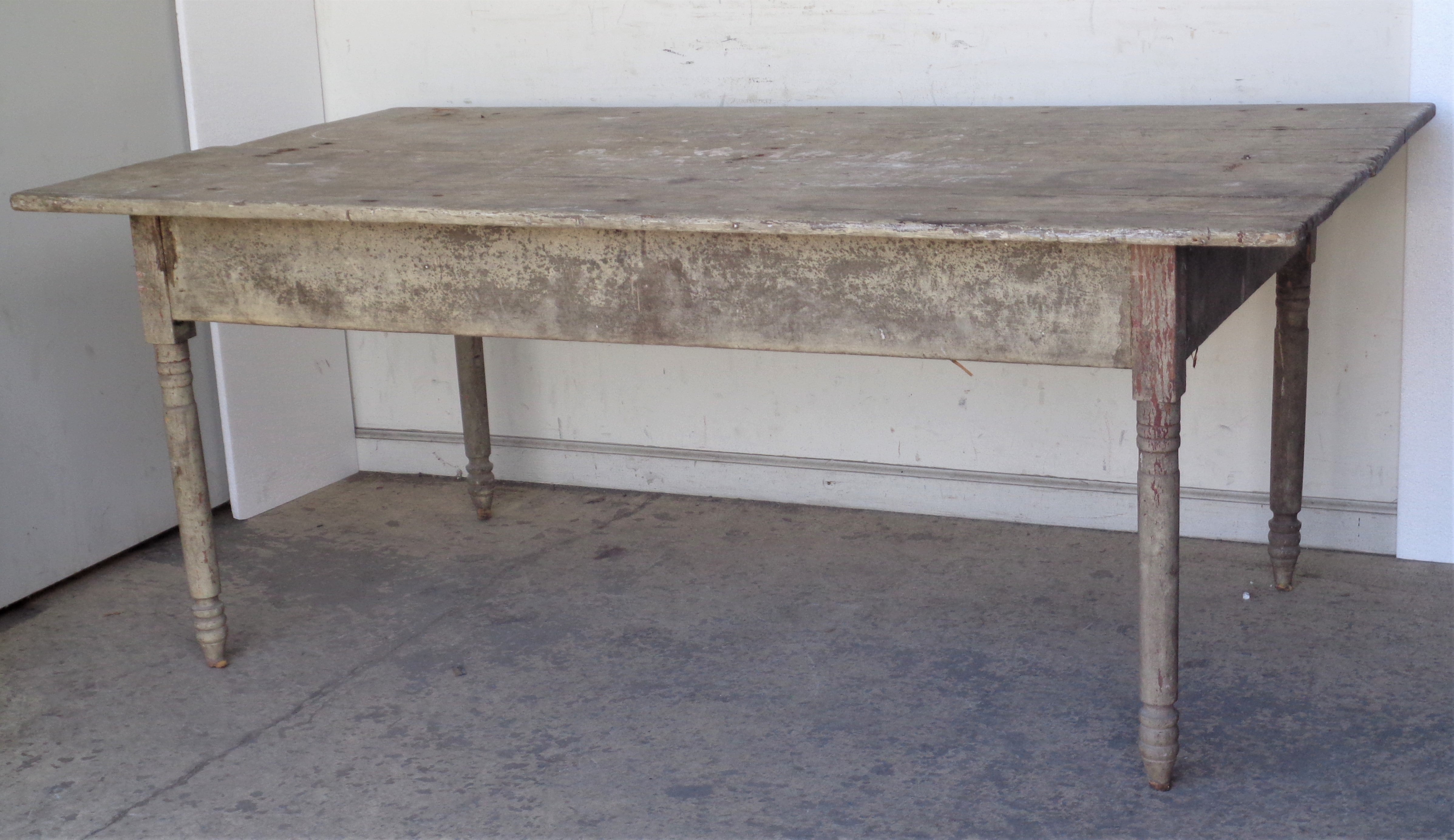 Antique American country farm table with turned legs / wide two board top in overall beautifully aged original worn old pale putty colored dry painted surface showing some underlying red wash at legs. All original early construction / large hand cut
