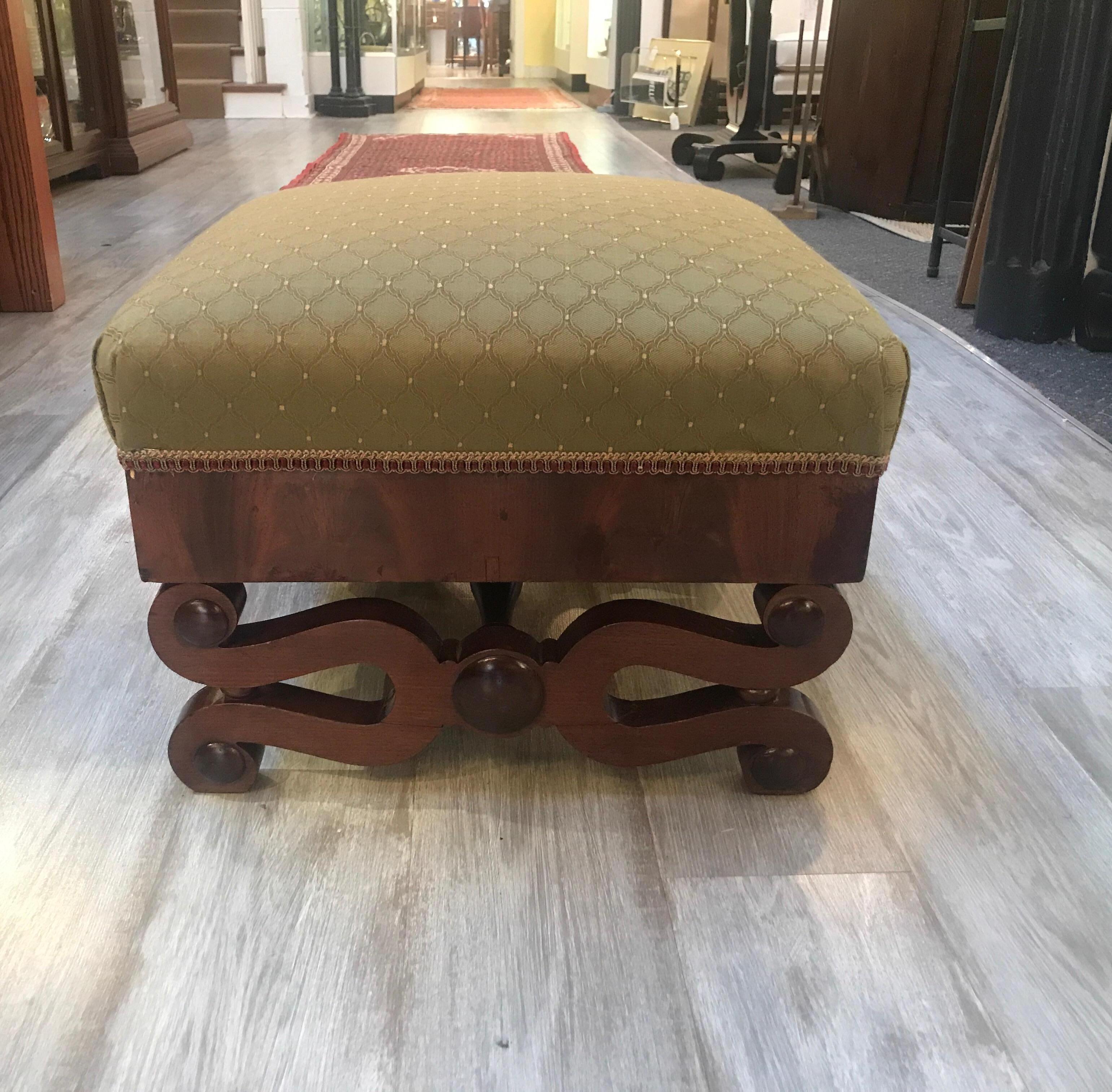 Handsome American Empire mahogany bench with new upholstery. The flame mahogany wood frame with elegant shaped base and new upholstery.