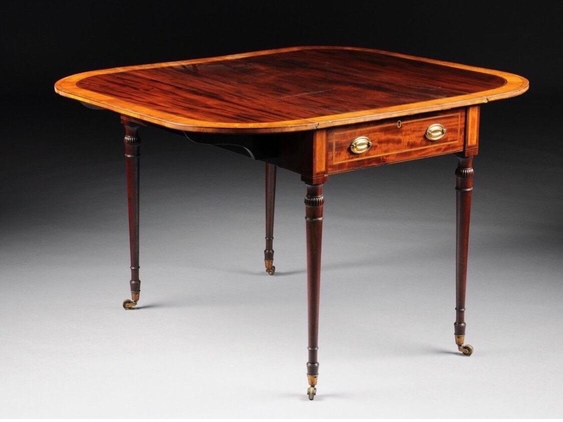 Early 19th century American federal mahogany table with maple, kingwood, and satinwood inlay. Rounded rectangular top with satinwood and kingwood cross-banding resting above a drawer with two oval brass pulls reversing to a similar sham drawer