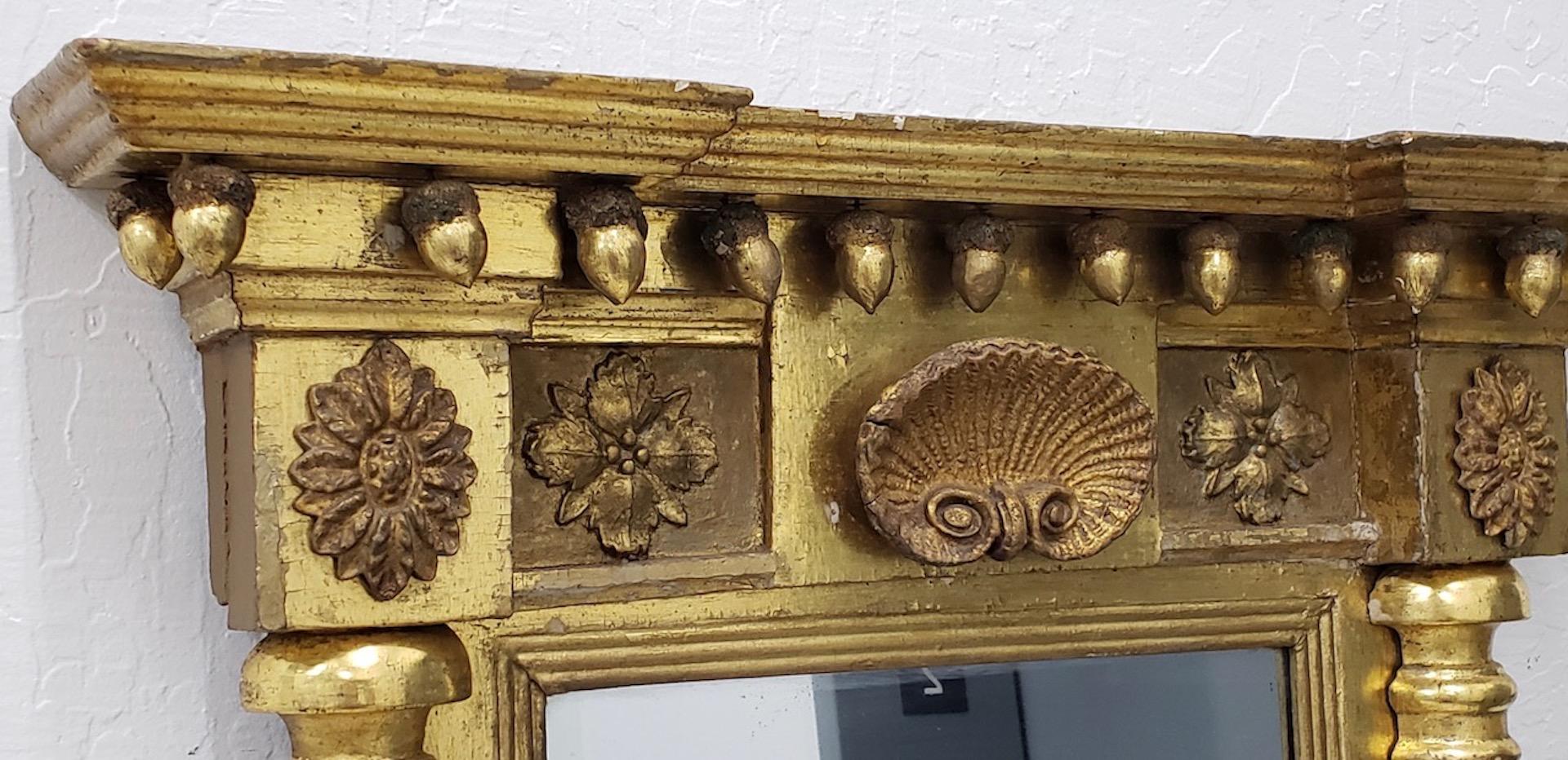 Early 19th century American hand carved and gilded mirror, circa 1820s

Wonderful early American antique mirror. Beautifully carved and gilded. Acorns hang from the top and a shell carving is at the middle. Beautiful twisted columns on each side.