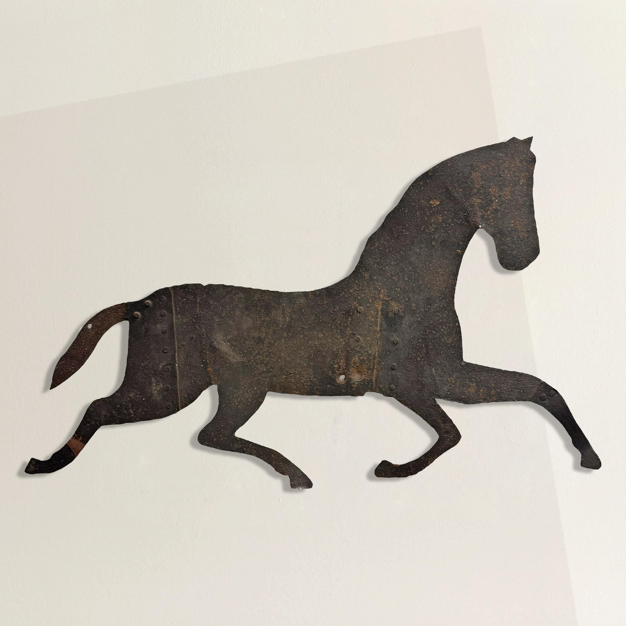 All muscle and motion, this early 19th-century American running horse weathervane still seems to gallop across whatever space it occupies. Fashioned from hand-wrought iron sheets—riveted together in multiple places to achieve its generous scale—it’s