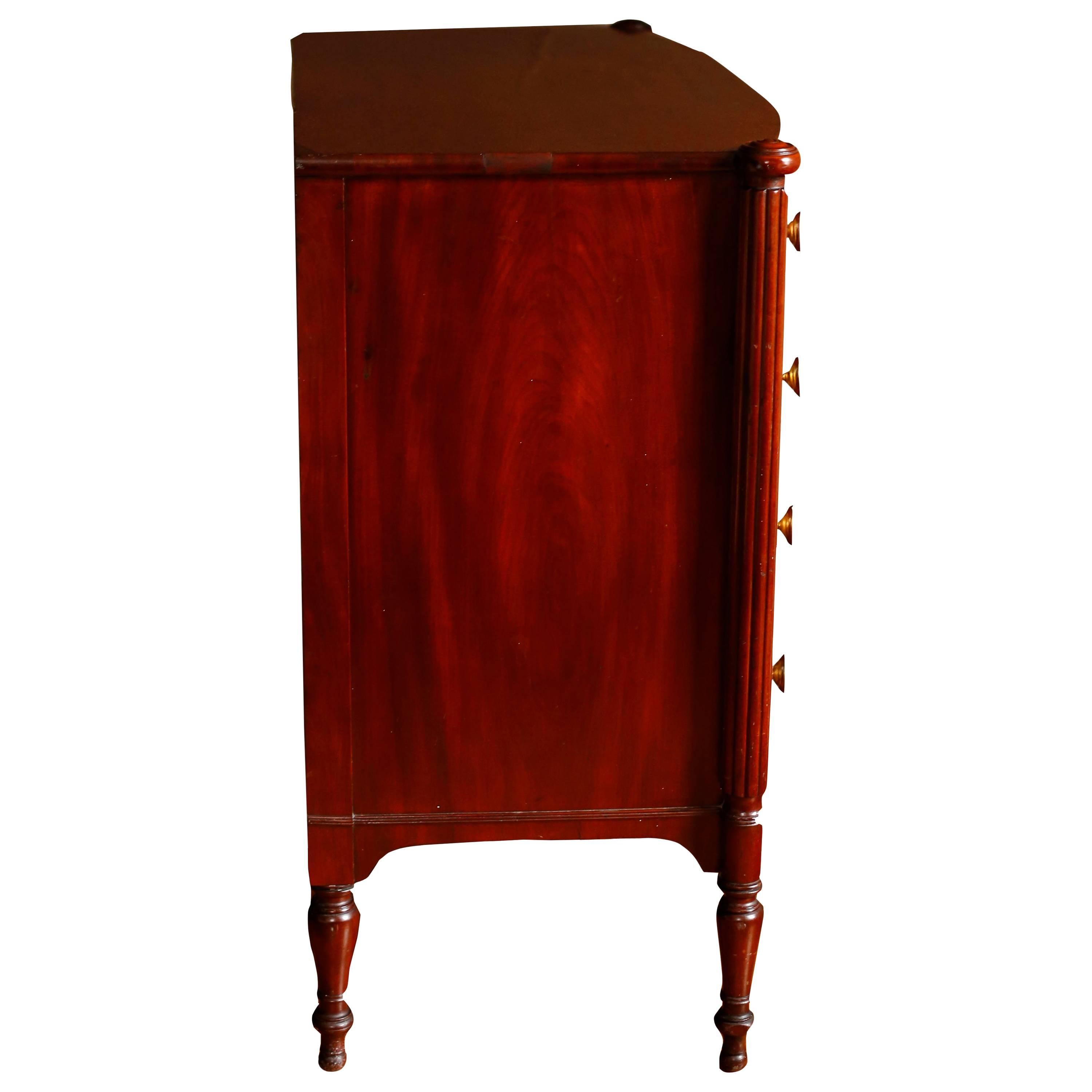 A very fine period chest from the North Shore of Massachusetts, likely the workshop of Samuel McIntire in Salem. The top with roundel ovolu corners conforms to the swollen front of the chest and rests on the reeded turrets of the corners which