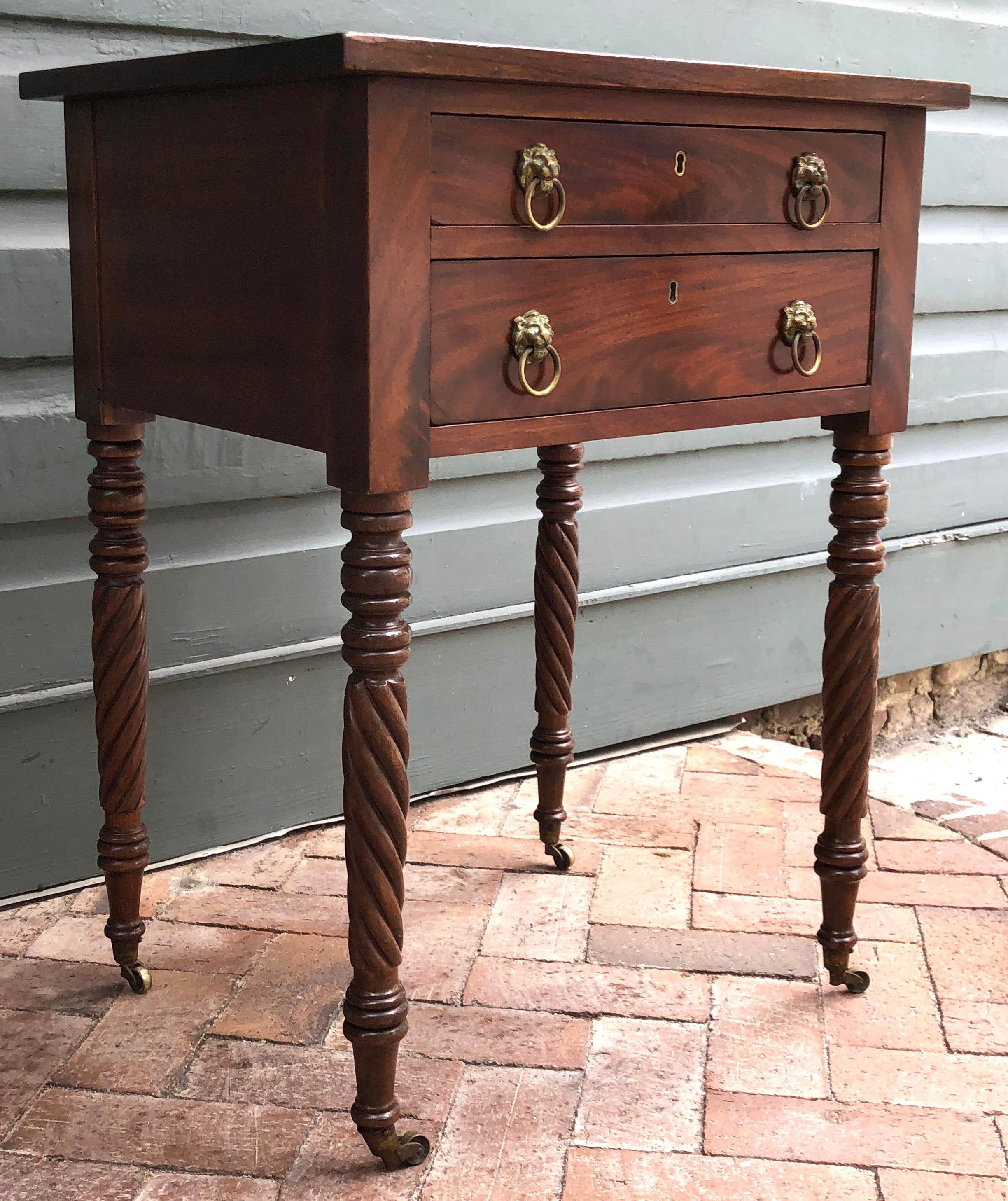 American Work/Side Table Made of Mahogany with Poplar Secondary wood, Circa 1820. The table retains the original lion head brasses and cup casters. Notice the rope turnings of the legs are opposite to each other. Mid Atlantic
