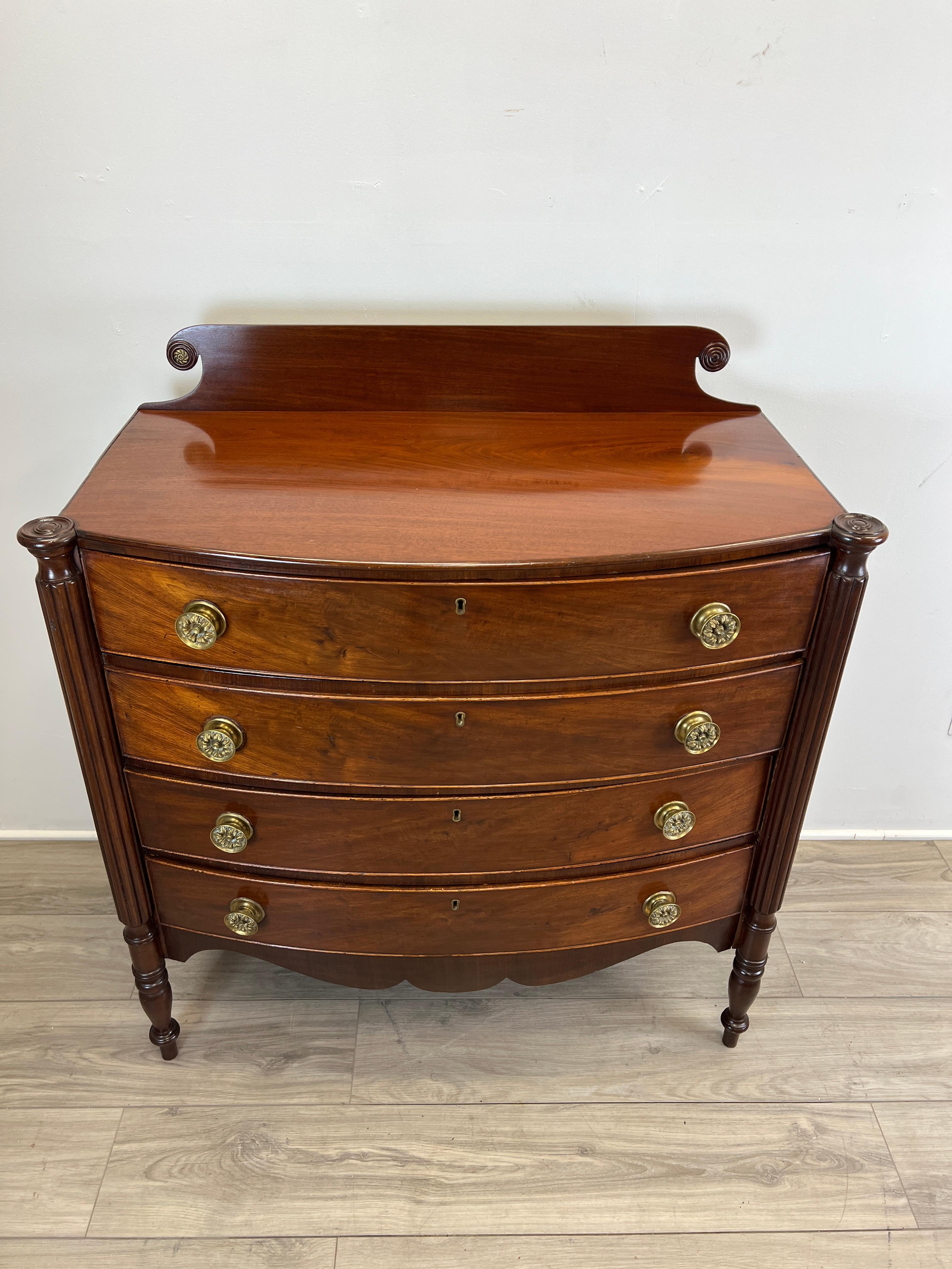 Featuring an exceptional early 19th Century American Sheraton bow front chest of drawers. The case is constructed of Honduran Mahogany. The drawers utilise yellow pine secondary woods as does the back and dust panels. There are four drawers all