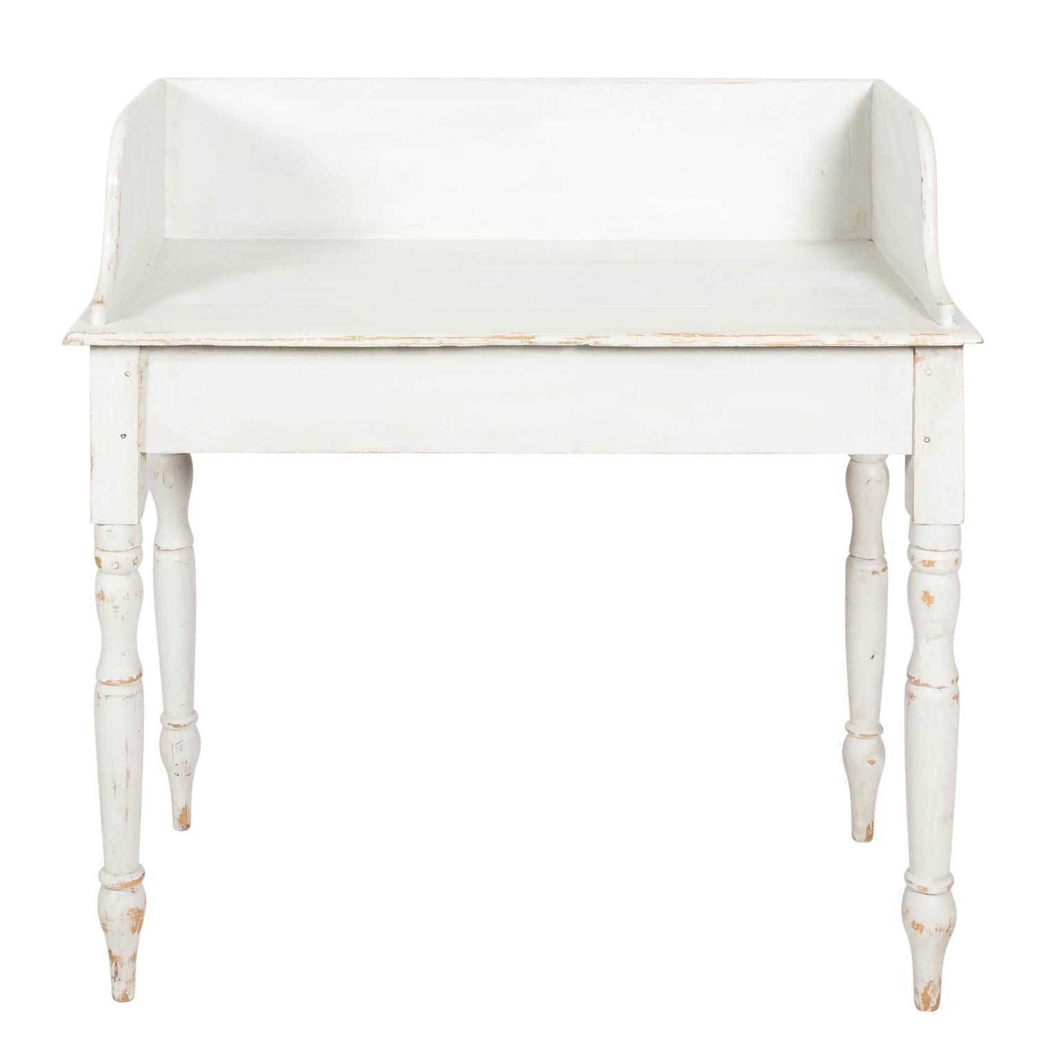 American white painted pinewood washstand with a curved gallery, ring turned legs, and arrow feet, circa early 19th century.