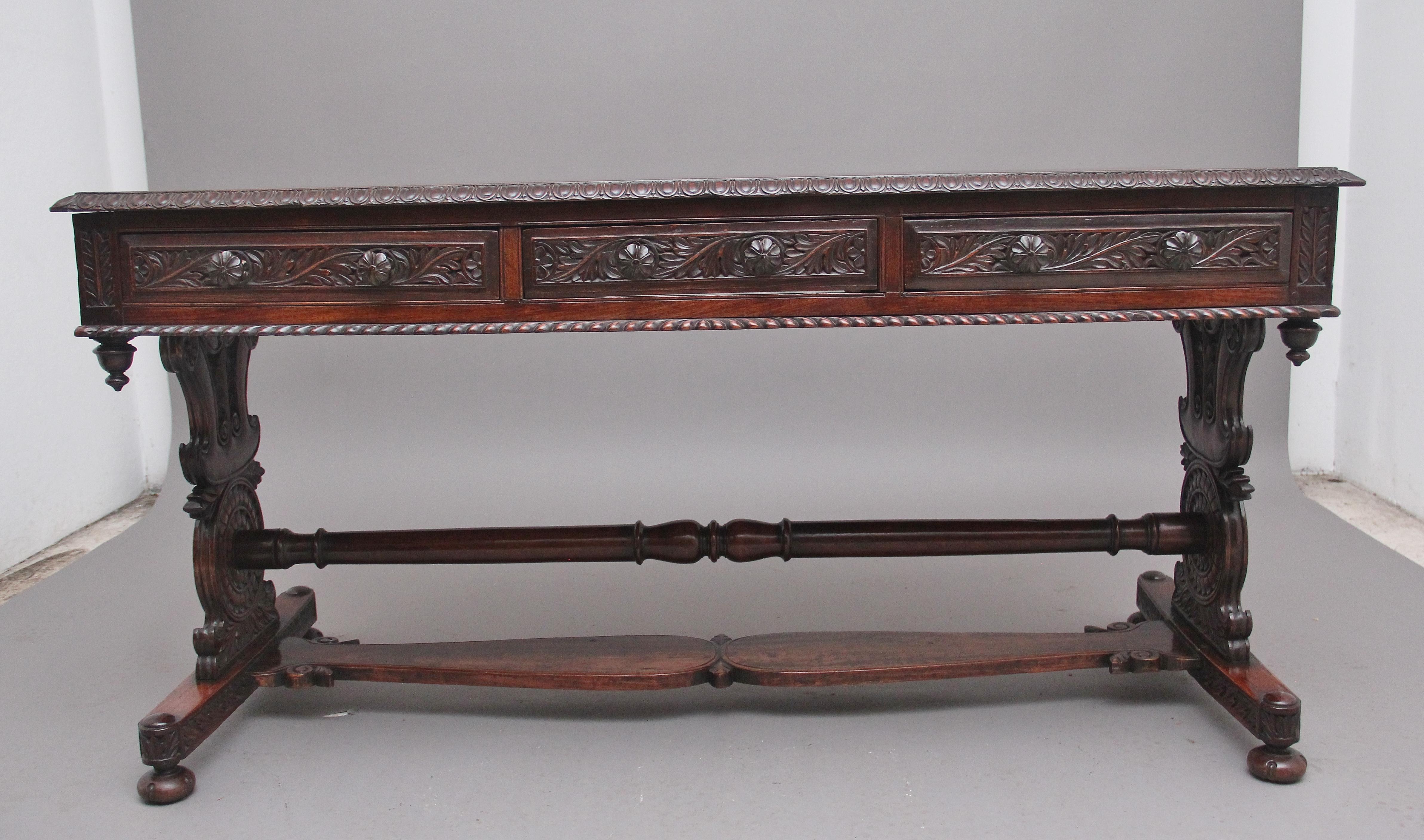 Early 19th Century Anglo-Indian teak serving / consul table, having a nice figured top with a decorative carved gadrooned edge, three frieze drawers below with the original carved wooden knob handles, carved floral decoration on the drawer fronts