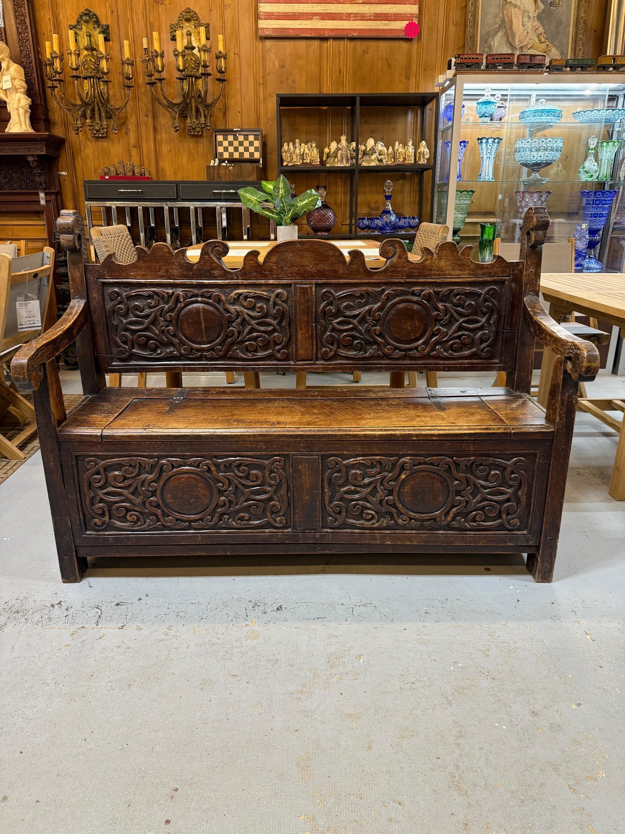 Fabuleuse banquette du début du 19e siècle sculptée à la main, avec assise relevable pour le rangement. Il s'agit d'une belle pièce avec de magnifiques sculptures sur le dossier et les panneaux avant. Construit à la main, il est fabriqué en bois dur