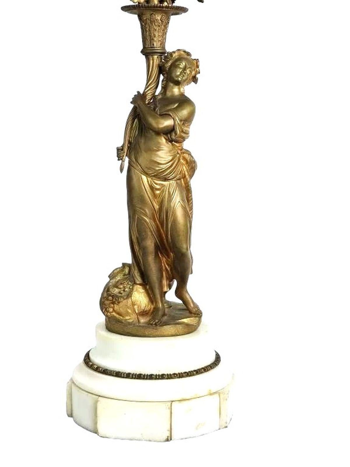 Coppia di candelabri in bronzo antico con 6 portacandele per ciascun candelabro. Bianco  La base arrotondata in marmo misura circa 13 di larghezza x 13 di profondità x 28,5 di altezza.