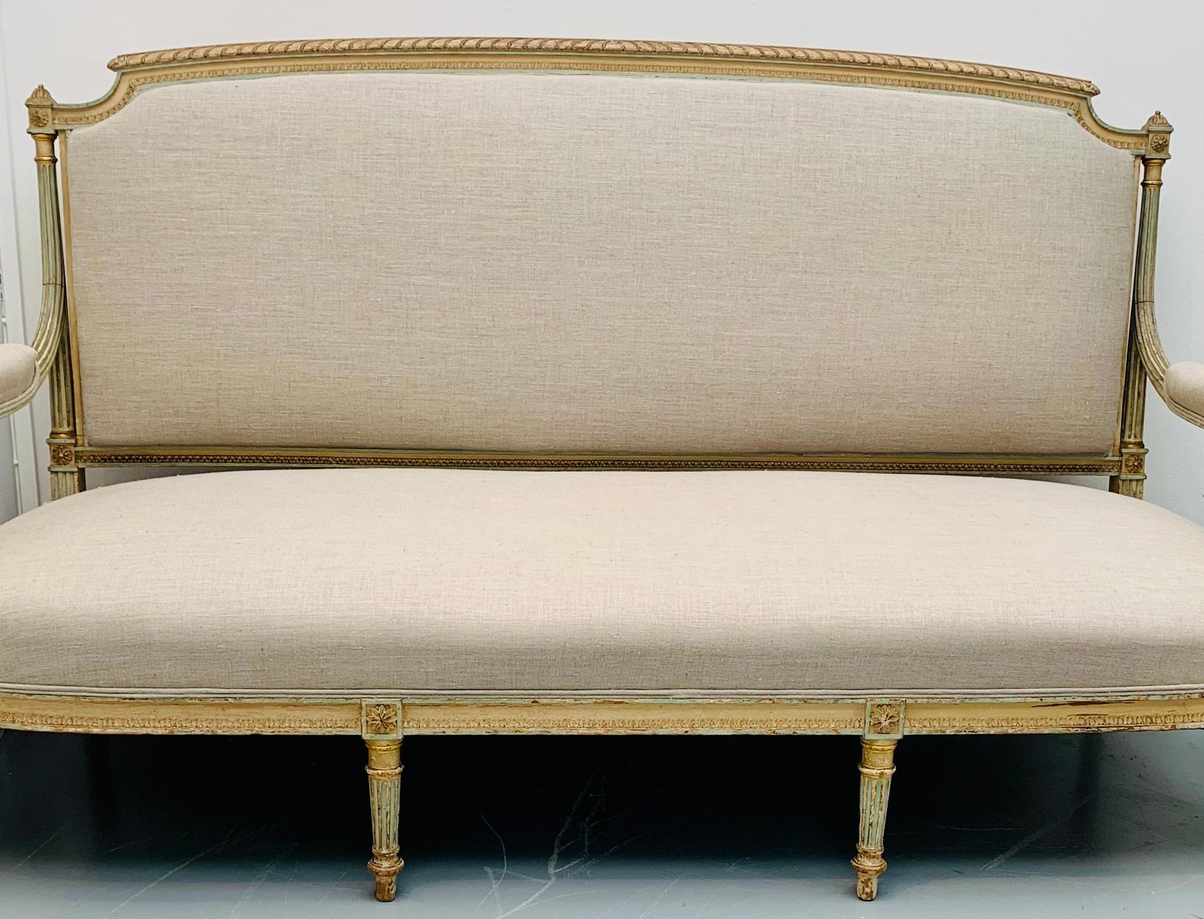 An early 19th century antique French original patinated sofa in the Louis XVI style. Carved wooden frame with its original Nile green and cream painted frame which is highlighted in gold leaf. 

The top part of the frame has a carved twisted rope