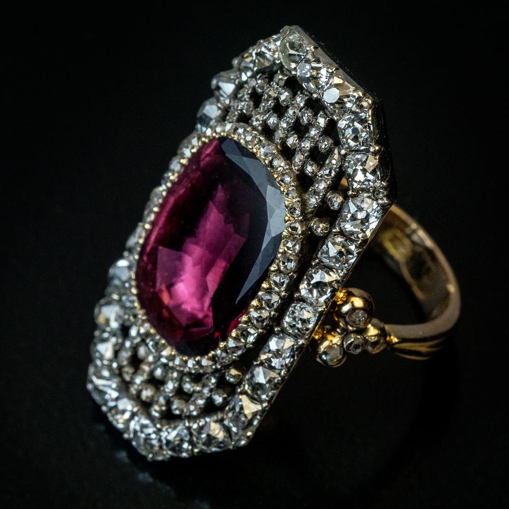 Circa 1820

This exceptional quality Georgian era ring is crafted in silver topped 14K gold (front – silver, back and shank – gold). The ring is centered with a pinkish purple garnet surrounded by an openwork bezel embellished with chunky old mine