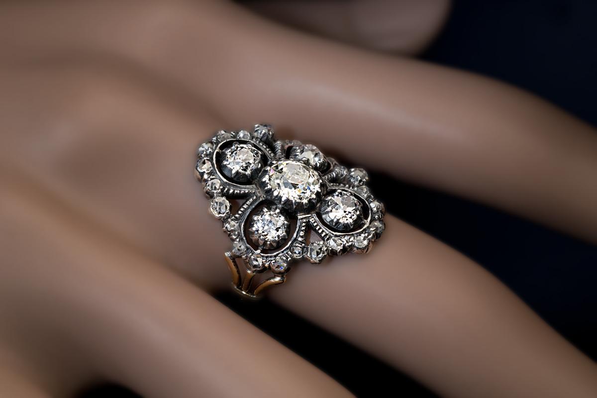 Circa 1830s

This late Georgian – early Victorian era ornate openwork ring is embellished with old cushion and rose cut diamonds. The diamonds are set in silver over 18K gold.

The center stone measures 5.64 x 5.18 x 3.2 mm and is approximately 0.72