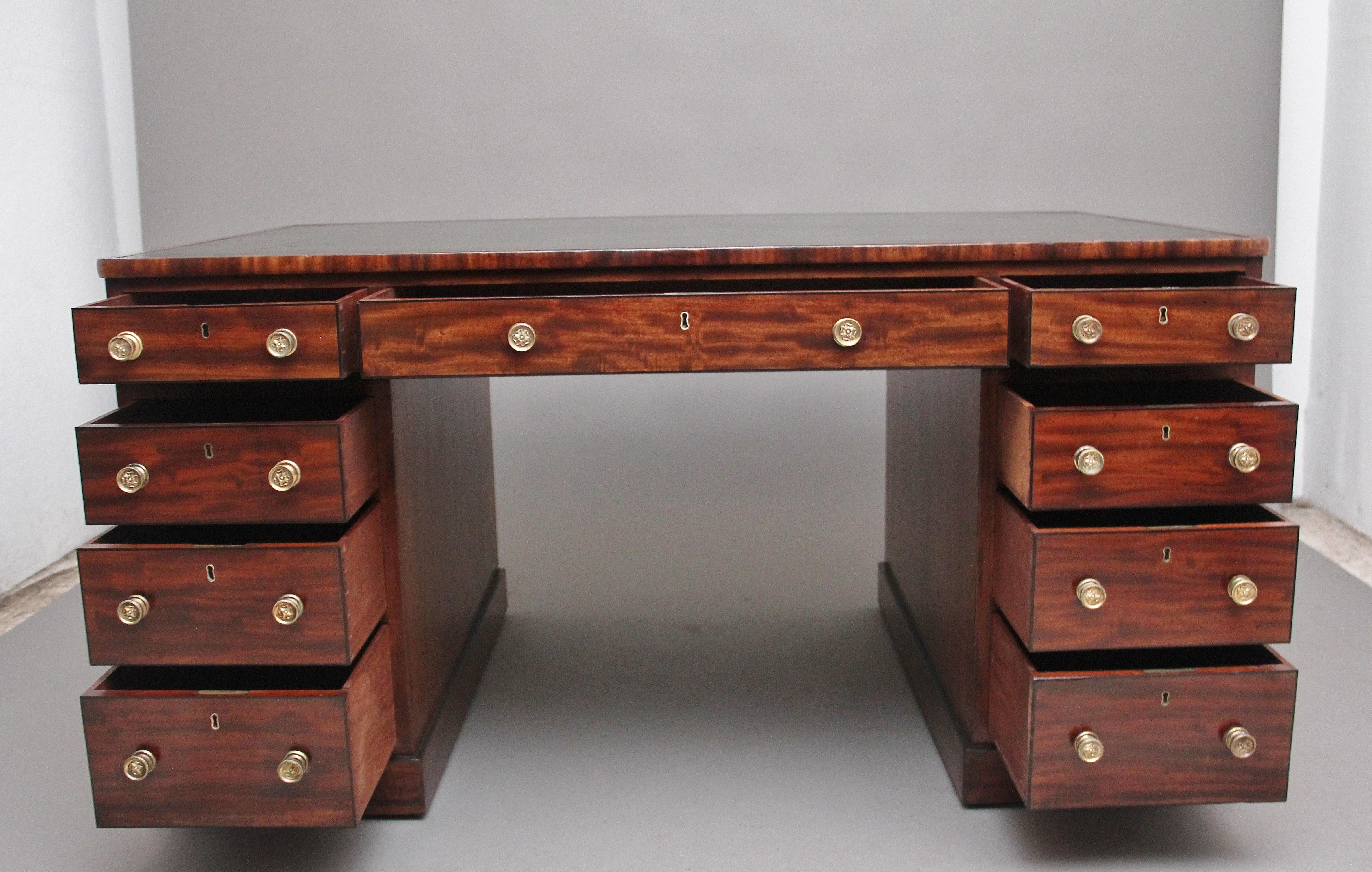 A lovely quality early 19th century mahogany partners desk, having a green leather writing surface decorated with gold and blind tooling, having an arrangement of nine mahogany lined graduated drawers, having the original turned brass engraved