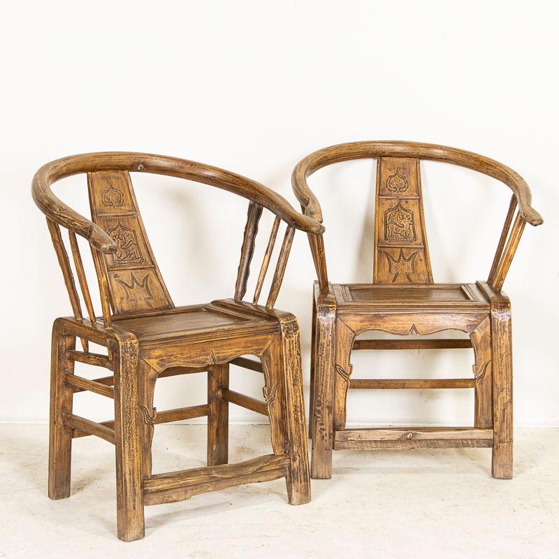 This attractive pair of arm chairs were crafted in the early to mid 1800's in China. The majority of the original finish has been worn away through generations of use, leaving a soft, smooth organic feel to the chairs. Note the traditional curved