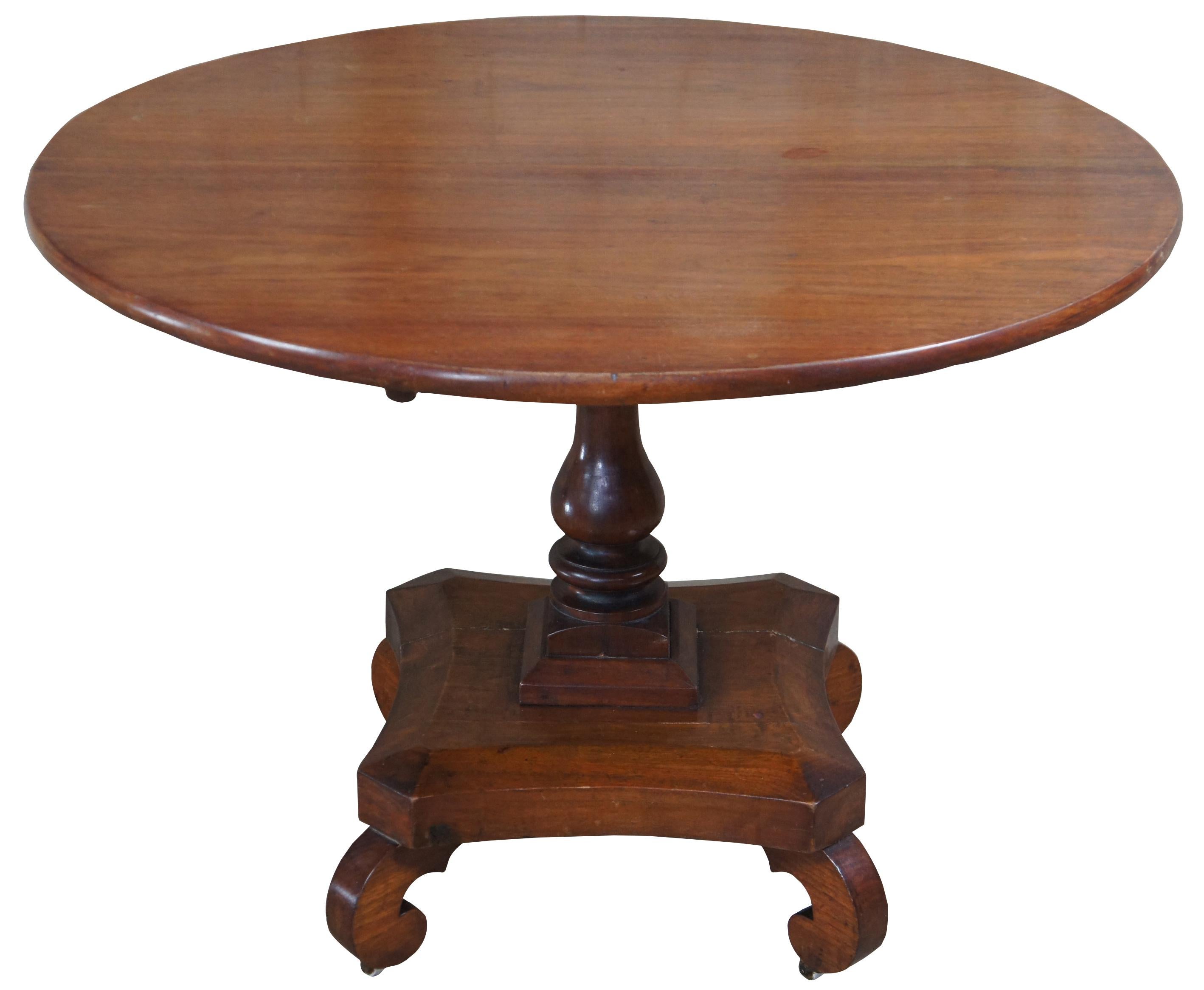 Mahogany tilt-top table, circa 1810 . Features a two board round top, turned column on quartrefoil base with four scroll feet and original brass casters.
 
Upright 40