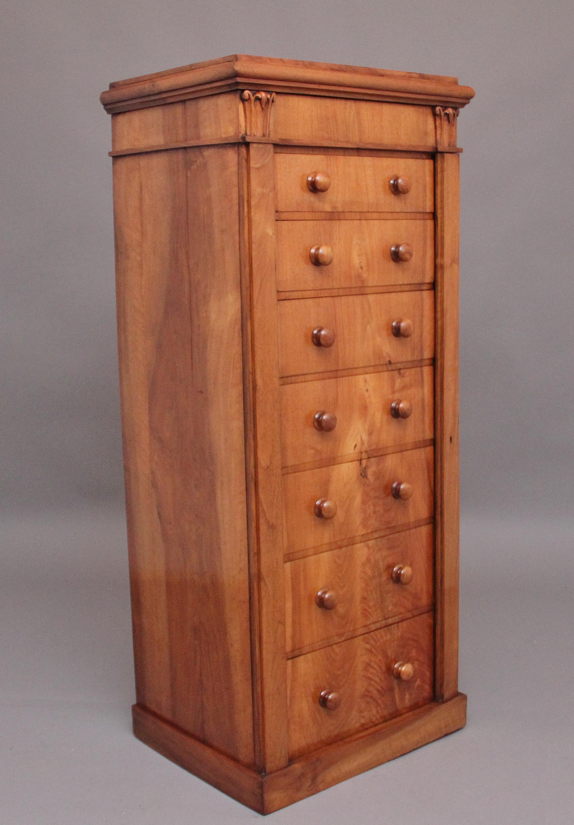 Cassettone Wellington in legno di noce, risalente agli inizi del XIX secolo, con un bel piano figurato che si trova sopra un cornicione sagomato; il piano incernierato si solleva per rivelare un ampio vano, con decorazioni a tulipano intagliate su