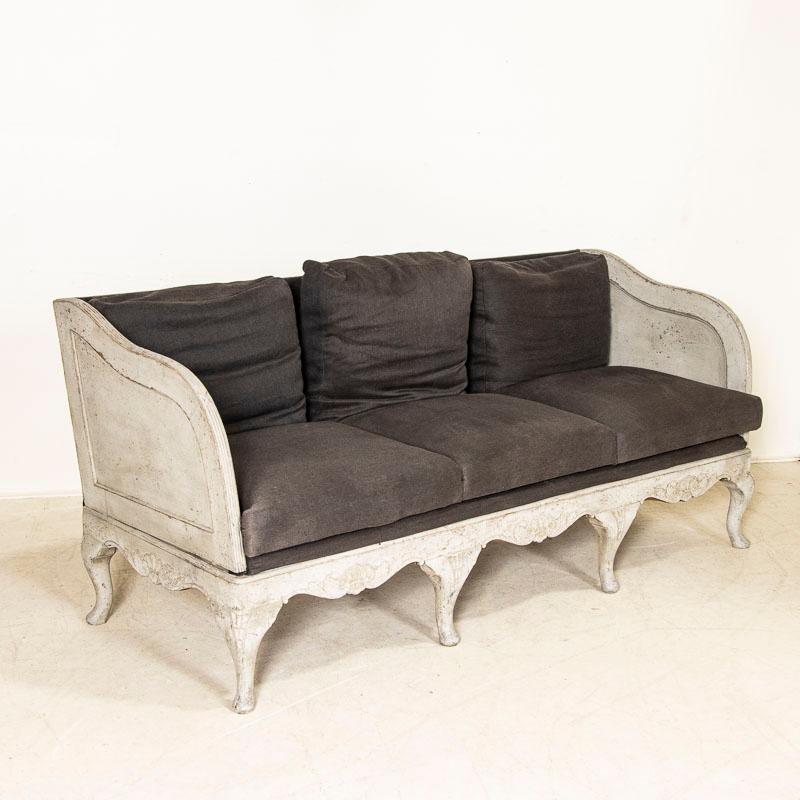 Dieses schöne Rokoko-Sofa ist ein besonderer Fund und spiegelt das anmutige Land wider, in dem man in den frühen 1800er Jahren in Schweden lebte. Die weiche, taubengraue Farbe, die im Laufe der Generationen des Gebrauchs leicht beschädigt ist. Die