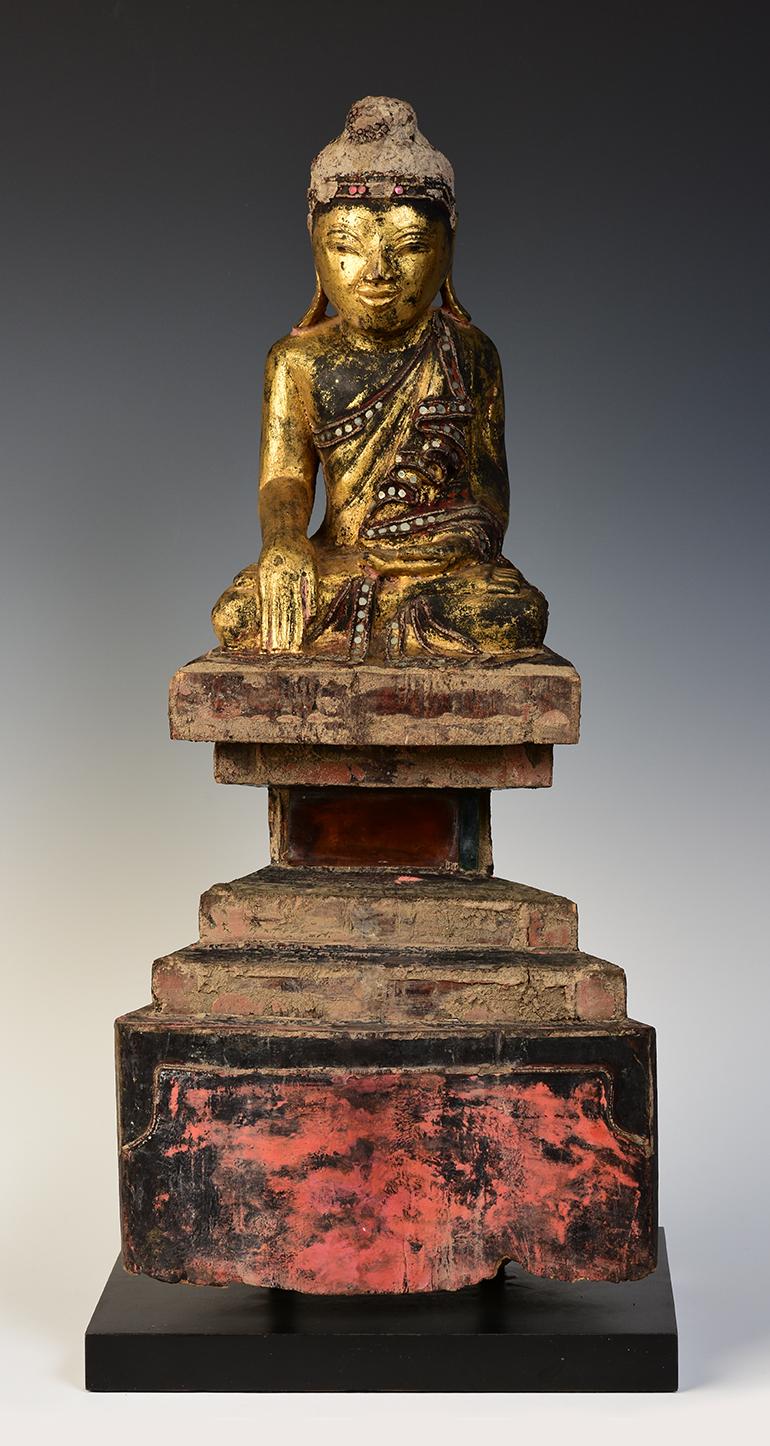 Antiker burmesischer Holzbuddha aus Tai Yai, sitzend in der Mara-Vijaya-Haltung (die Erde zum Zeugen rufen) auf einem Sockel.

Die Tai Yai sind ein Stammesvolk, das in Birma lebt. Es ist schwierig, Buddha aus dieser ethnischen Gruppe zu