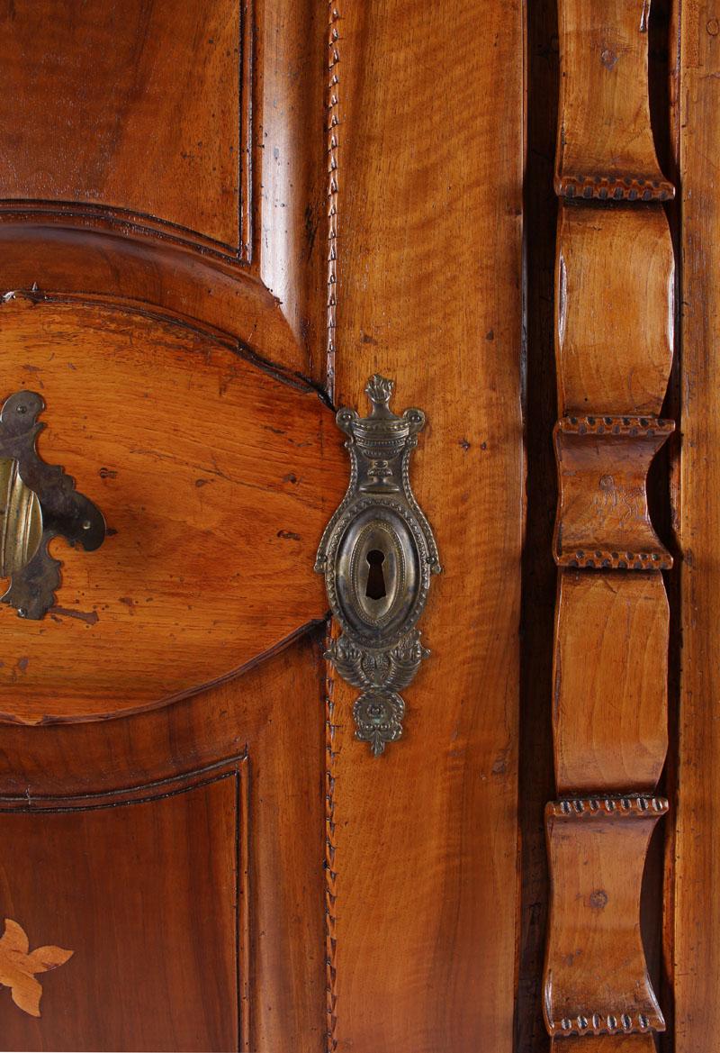 Armoire with inlays

Southwest Germany
Walnut,
beginning of the 19th century

Dimensions: H x W x D 210 cm x 156 cm x 49 cm

Description:
Solid walnut body standing on ball feet.
Beveled pilaster strips with flowers inlaid in maple in