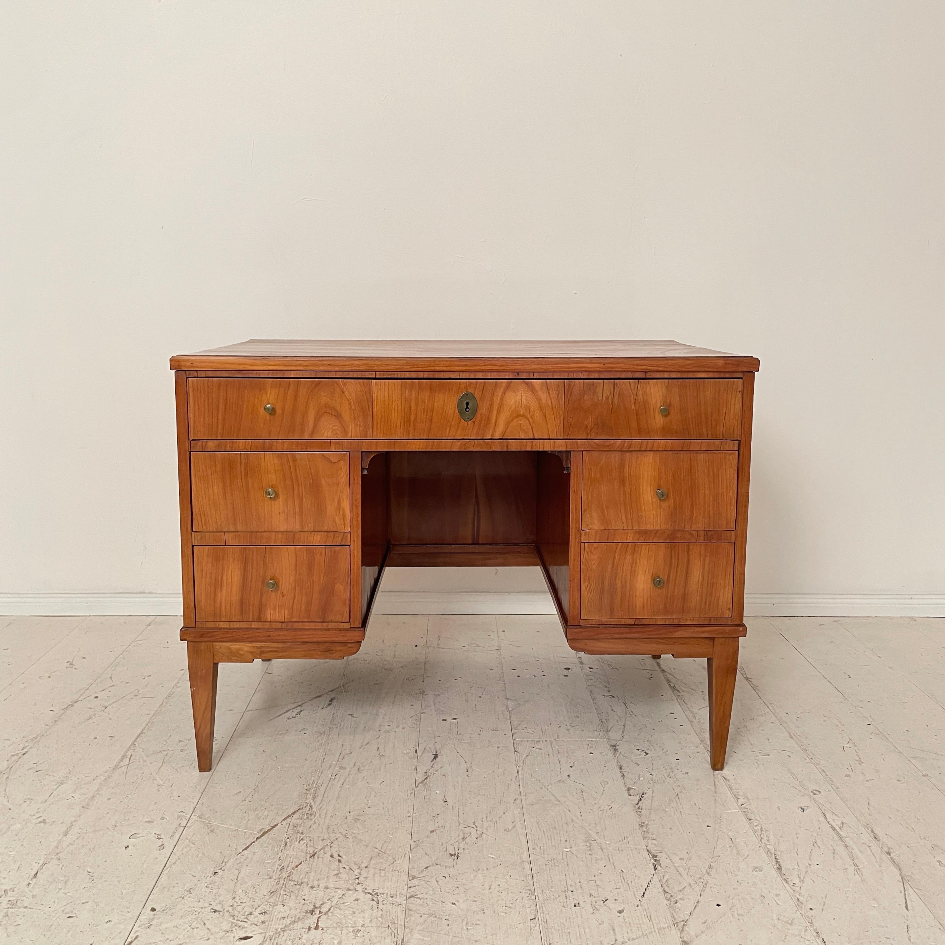 This early 19th century antique Austrian Biedermeier desk or writing table is made out of Pine and is veneered in light brown cherry wood. It was made around 1810.
The piece of furniture is in wonderful original antique condition. It remains the