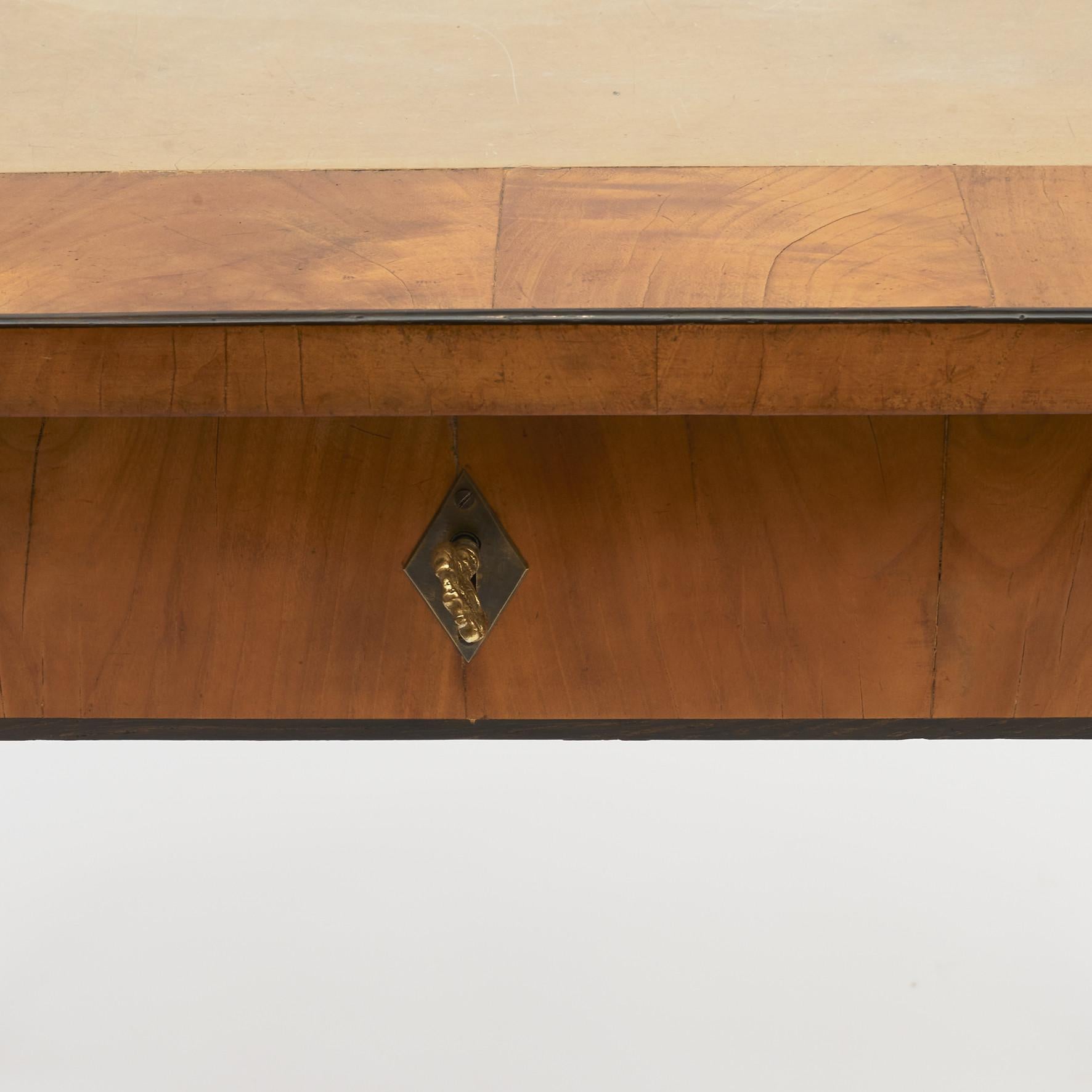 A Austrian Empire center table with a single drawer. Cherry veneer with ebony trim and inlayed limestone top on elegantly tapered legs with ebony feet.
Austria, circa 1810.
In good original condition, with a gentle French polish.
     