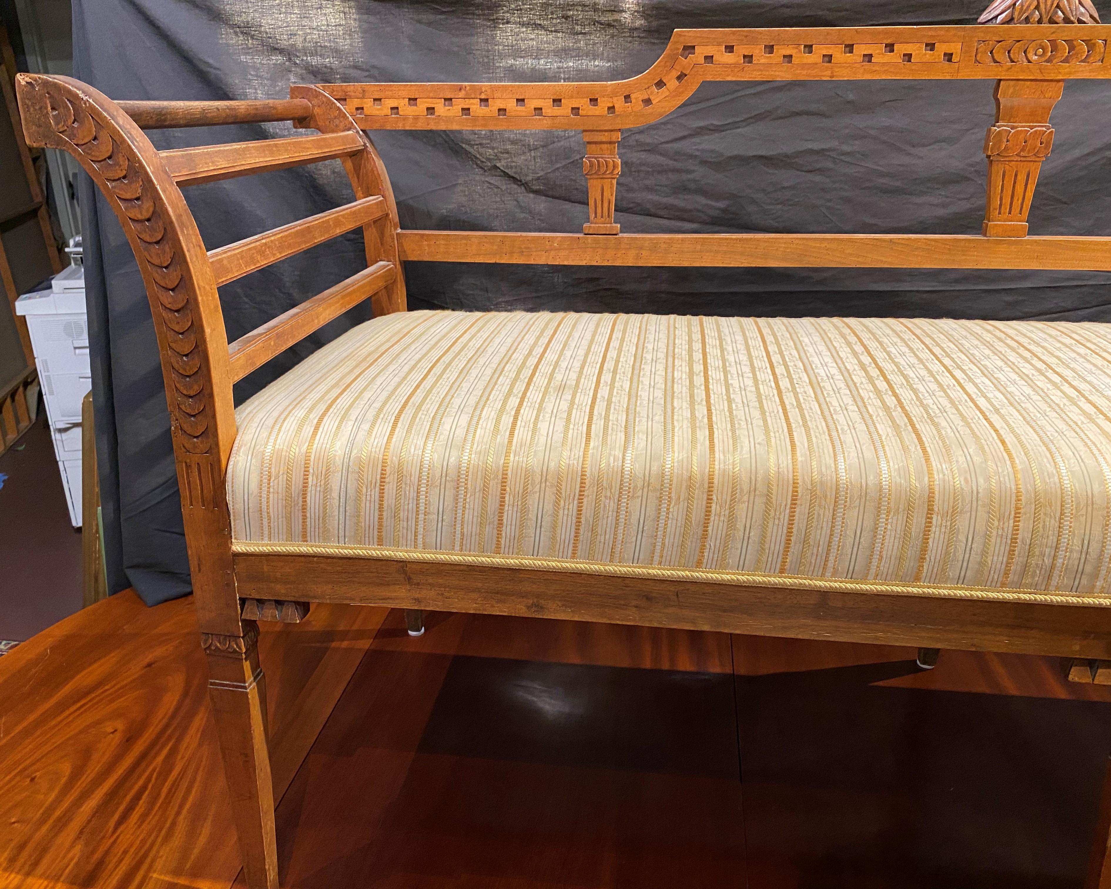 A fine form fruitwood settee with outward splayed arms, upholstered seat and nicely carved elements, supported by six tapered square legs. Austrian, dating to the early 19th century in very good overall condition, with some losses, crest repair,