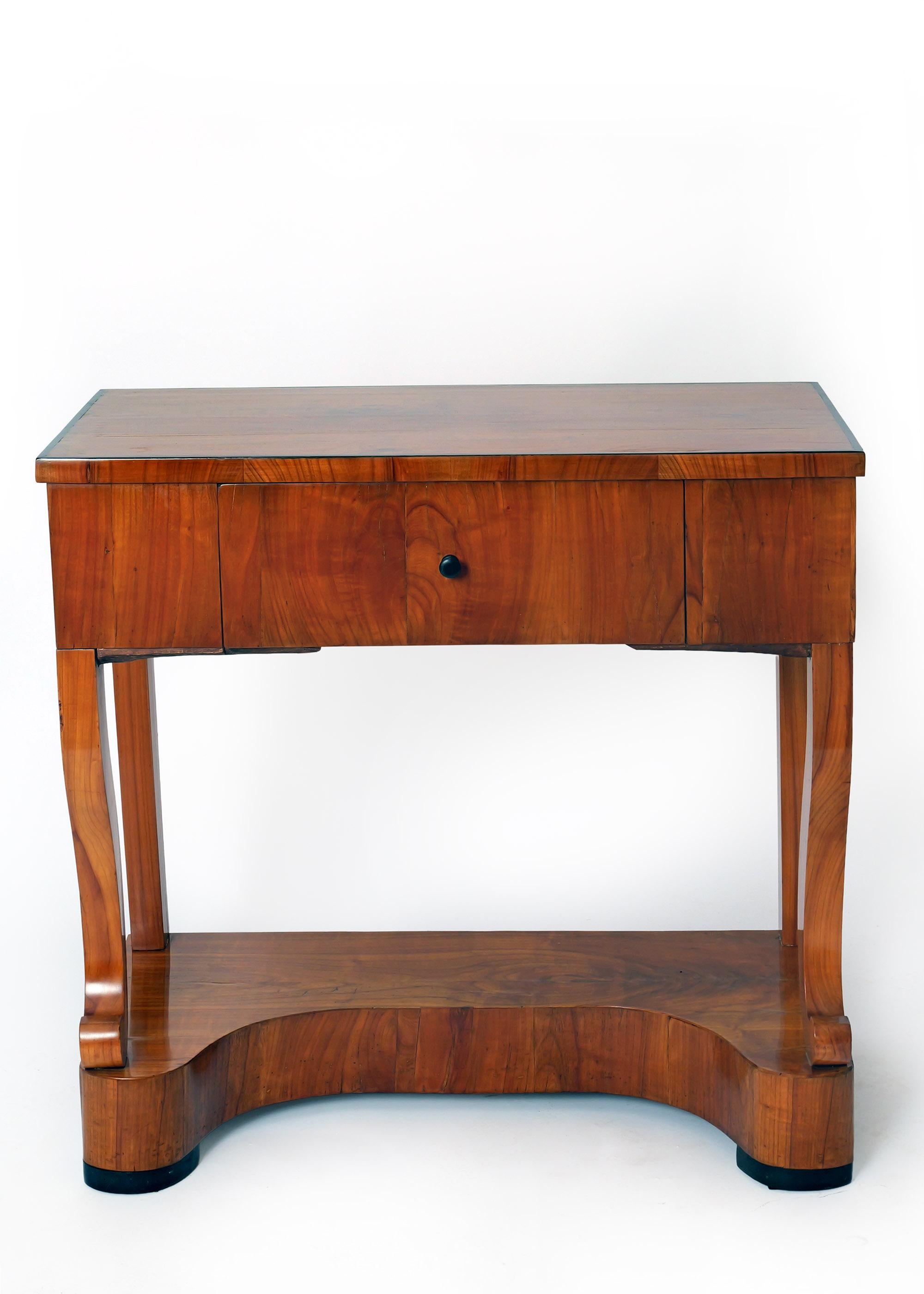 Console Biedermeier du début du 19e siècle en Allemagne du Sud. Pieds avant en bois de cerisier à volutes, tiroir ouvert à l'arrière. Vers 1820, Allemagne du Sud. Cette magnifique table console Eleg est plus légère qu'elle ne l'est grâce à son