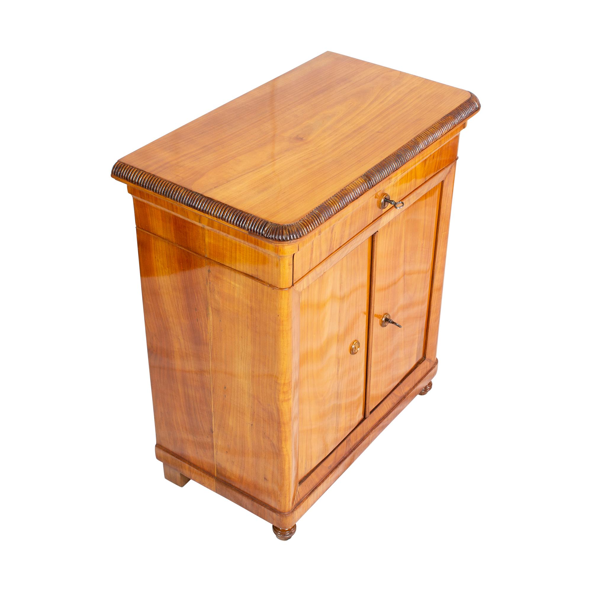 Beautiful practical small cabinet from the Biedermeier period in cherry veneer / solid. Top with a drawer to close and 2 doors to close. The cabinet is in very good condition, hand polished with shellac.