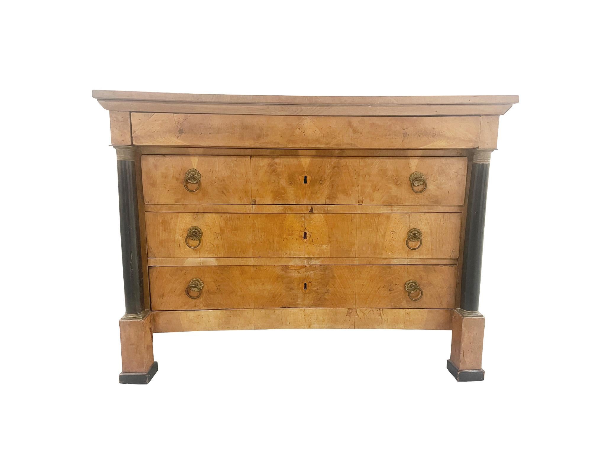 Hand-crafted in the 19th Century, this Biedermeier chest of drawers is constructed with one narrow compartment atop 3 larger drawers. Decorative features characteristic of the Biedermeier style include black front columns and ormolu pulls and foot