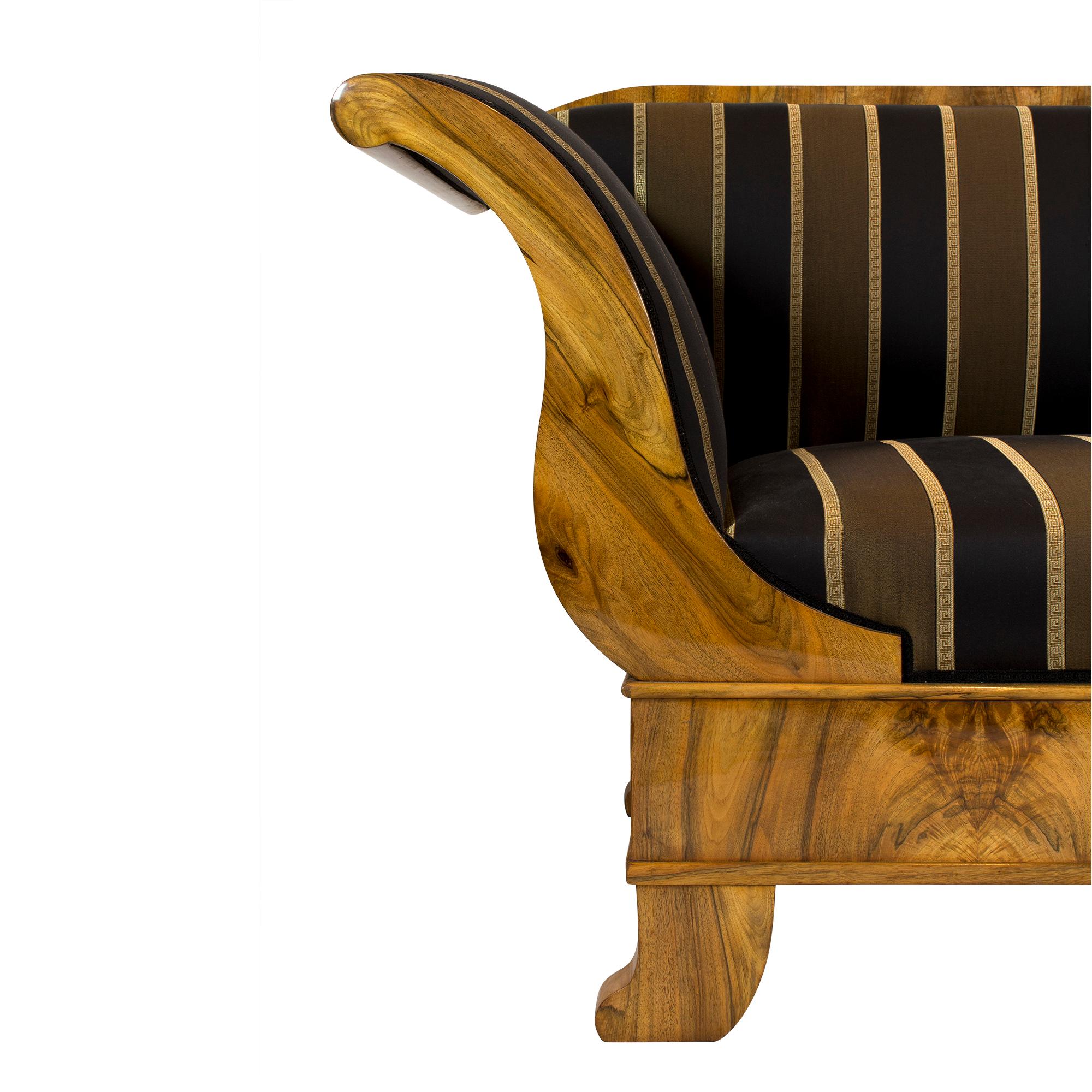 Das Sofa stammt aus der Biedermeierzeit zu Beginn des 19. Jahrhunderts. Der Korpus des Sofas ist aus Fichtenholz gefertigt und wurde mit einem sehr schönen Nussbaumfurnier überzogen, das gespiegelt angebracht wurde. Das Sofa ist in sehr gutem
