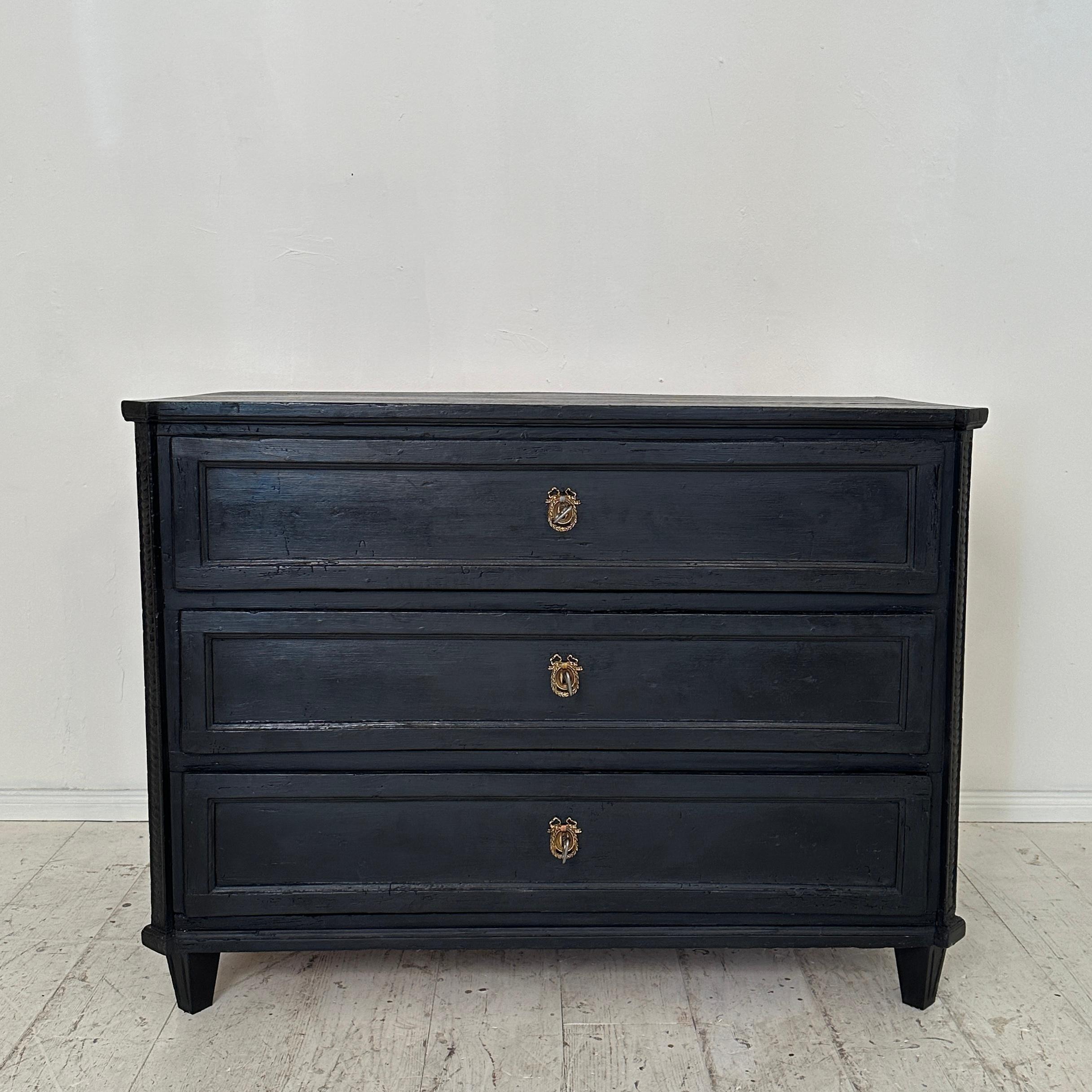 Crafted around 1800, the Early 19th Century Black Empire Chest of Drawers with Three Drawers embodies the opulence and grandeur of the Empire style. Made with meticulous craftsmanship, this chest exudes an air of regal sophistication. Its sleek