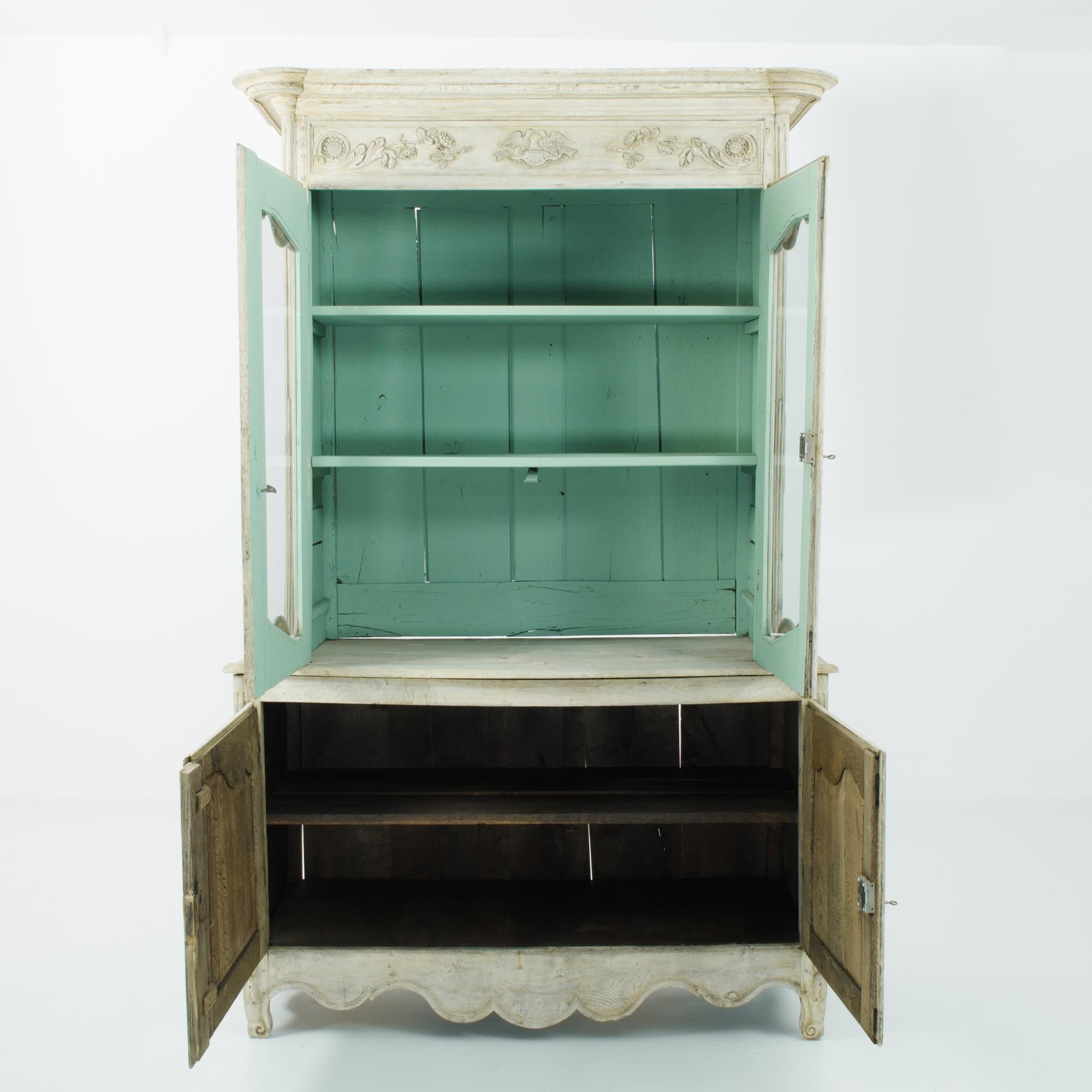 This two-part bleached oak vitrine was made in France, circa 1800. Imparting the refined and idyllic air of a rustic farmhouse-- this wholesome pantry features a shelved interior painted a lighthearted green, visible through the glass panes in the