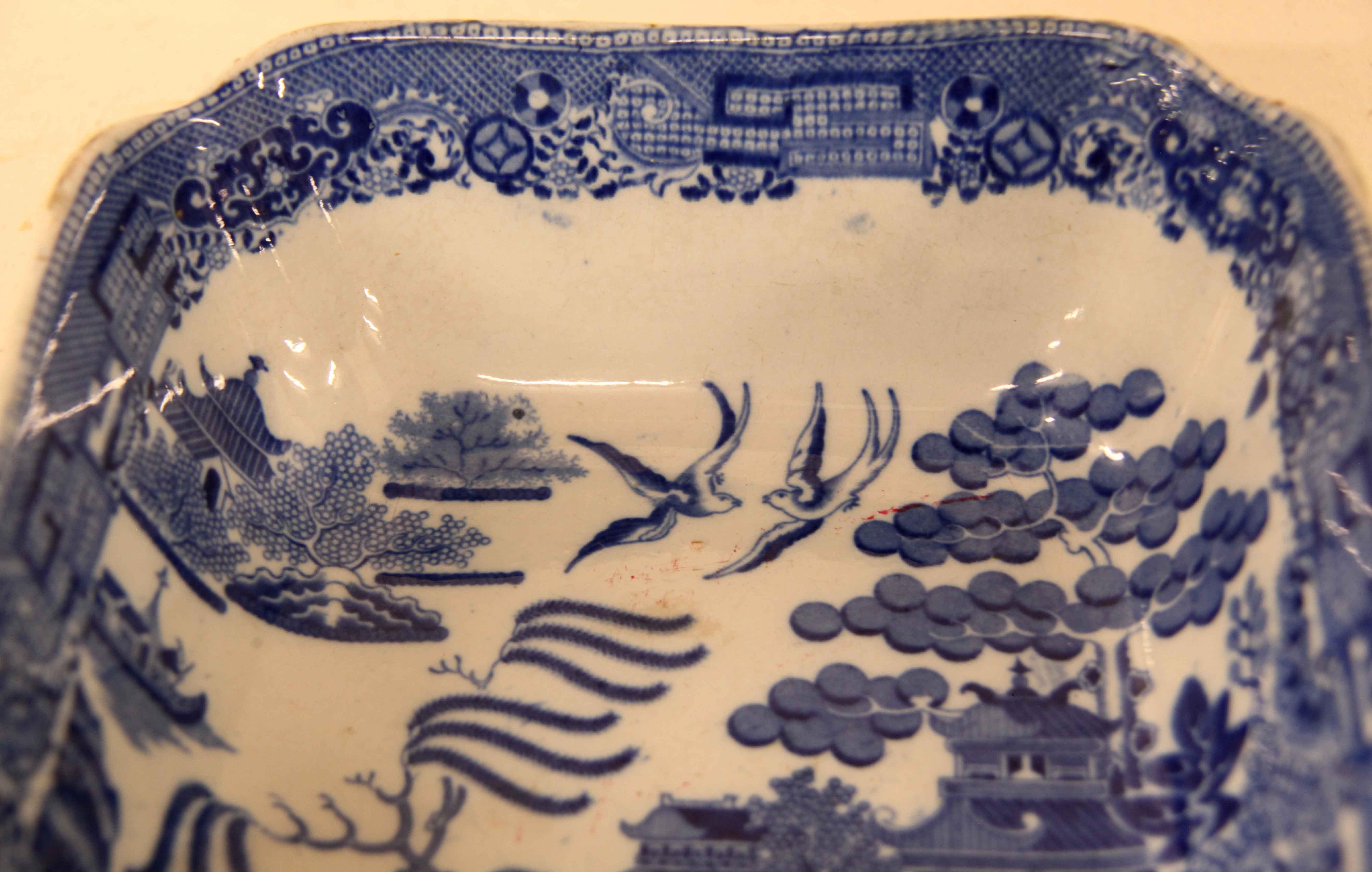 Early 19th century blue willow bowl,  with the typical oriental scenes of this pattern- pagodas, trees, birds, bridge with people, flowers and foliage.  This square bowl has pinched corners and is in very good condition.  If one notices