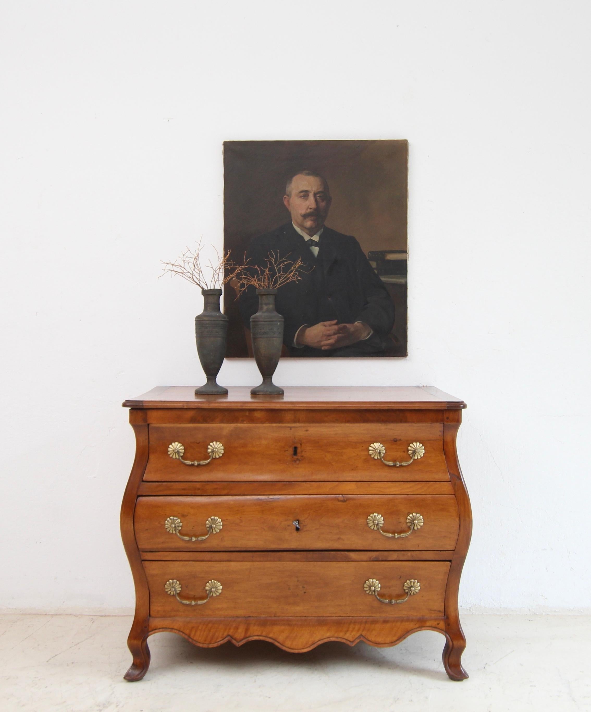 Una cassettiera provinciale bombe o 'commode tombeau' in stile Luigi XV/Transizione. Inizio del XIX secolo. Realizzato in ciliegio e noce. Restaurato per l'uso quotidiano.

Corpo a tre cassetti in noce e ciliegio, bombato su tutti i lati, a