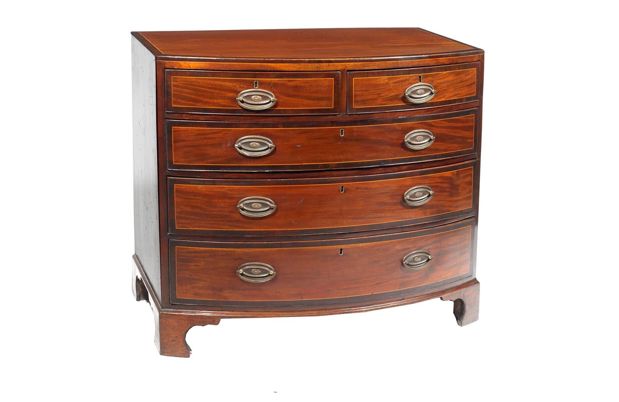 Early 19th century George III mahogany bowfront chest of drawers in the Thomas Sheraton, the shaped crossbanded top with satinwood line inlay raised over two short and three long crossbanded and cockbeaded sets of drawers with satinwood line inlay