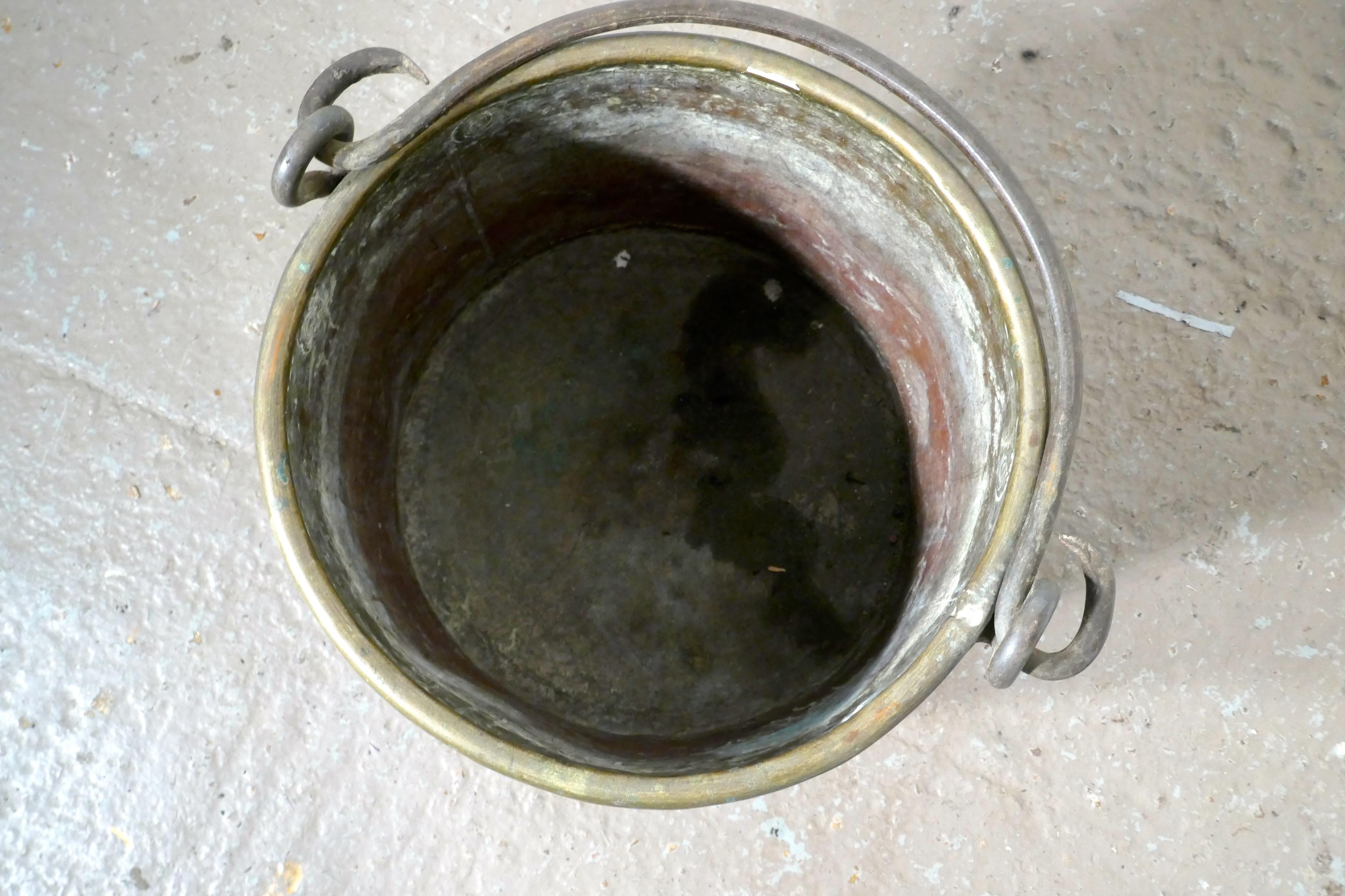 Early 19th century brass cooking pot

This is a lovely looking 19th century cooking Pot, it has been used as a log bucket and works very well as such.
The pot has a rolled top and the Iron handle swings through 180 degrees, the bucket is in very