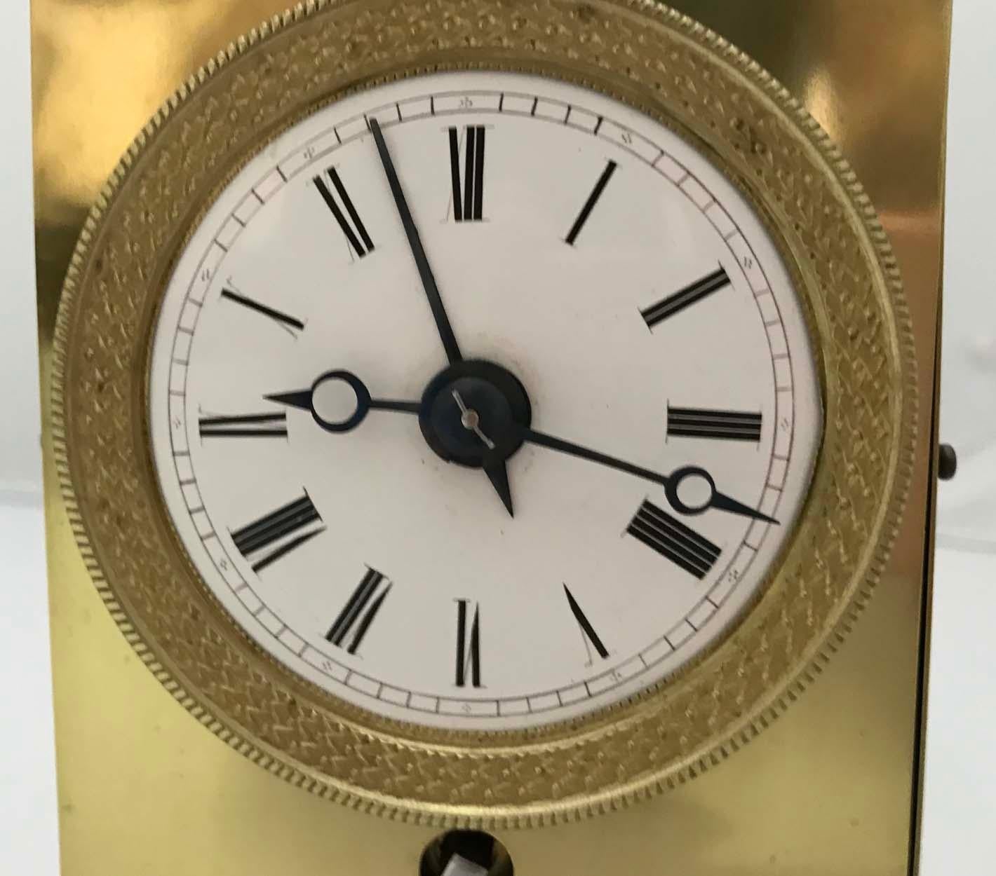 A French brass Capucine Officers clock with alarm, circa 1820.

The case of typical form, with doors to the sides and rear, urn finials to the top corners and flanking a polished steel bell, on toupie feet, the enamel dial with Roman numerals and
