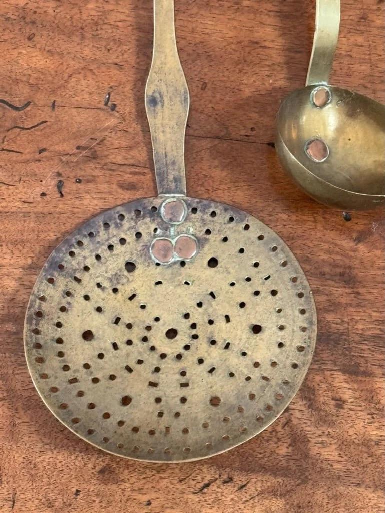 Early 19th Century Brass kitchen utensil hanger with utensils, marked 18ll having multiple kitchen implements.  21.5” h. a 20.25” w. x 3” d. 

