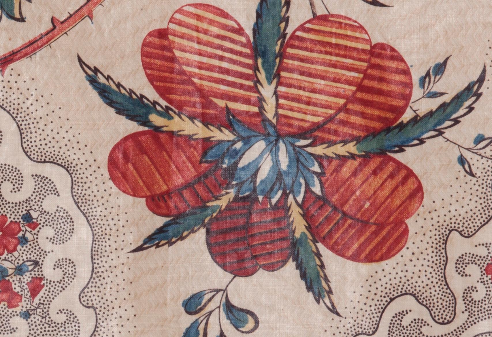 Made using natural dyes and copperplate printing, this early 19th century cotton textile fragment features elaborate florals and tiny dots on blocks for background texture, as well as a chintzed (glazed) surface. This piece is offered as a historic