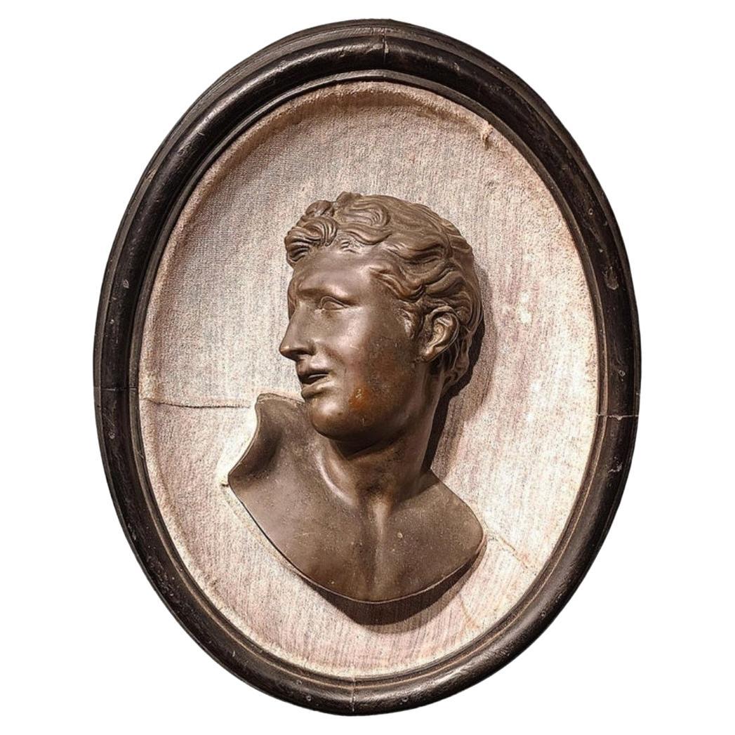 Early 19th century mounted bronze 3/4 profile. Likely French but possibly English. Carved wooden backing custom just for this particular item. In the original frame and retaining an old if not original striated pale blue velvet.
This is now on view