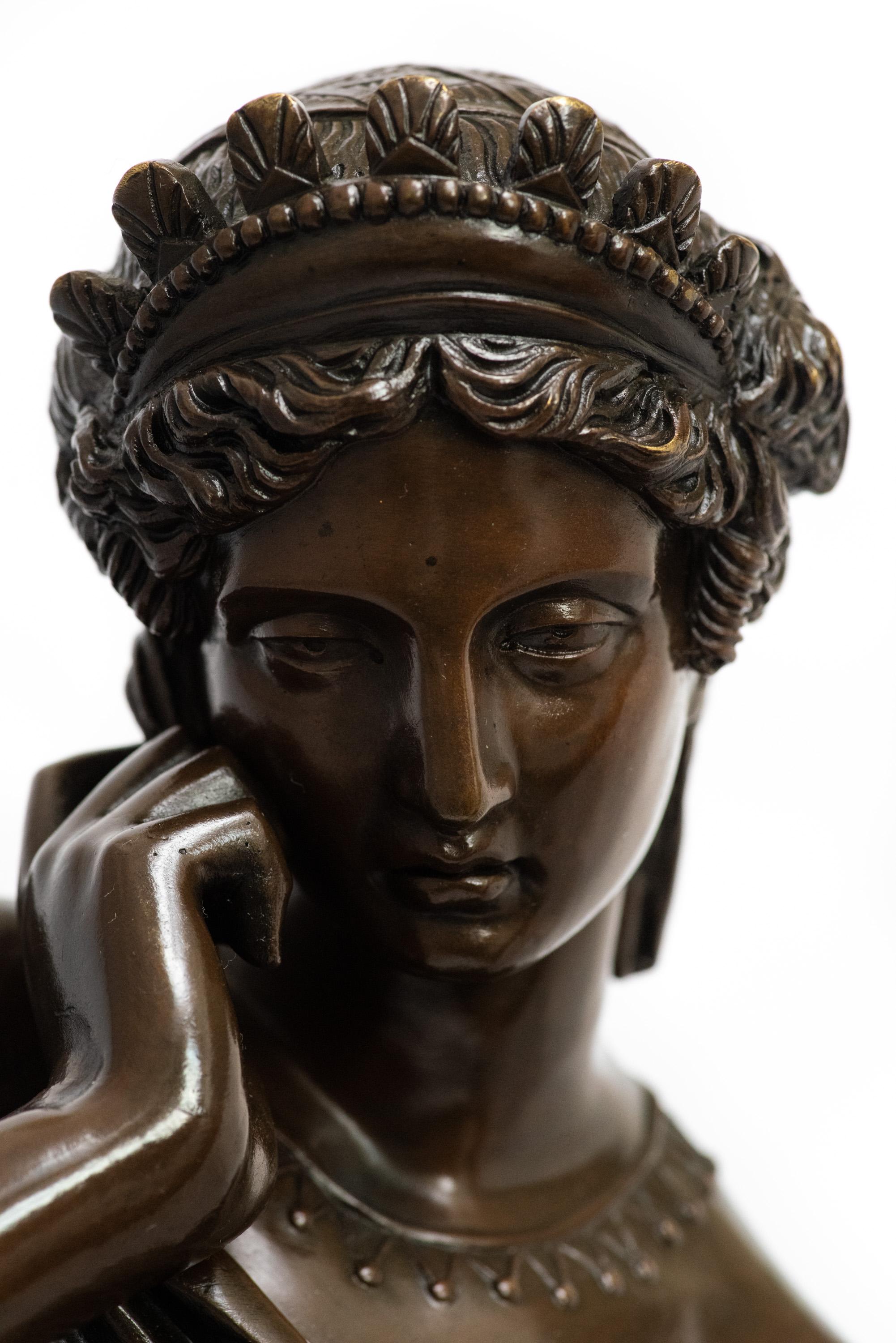 A pensive figure, evocative to the many depictions of Sappho produced during the Romantic Era, of a seated woman by the French sculptor Eugène Louis Lequesne (1815-1887). She and her soft antique patina are in perfect condition. She rests on a noir