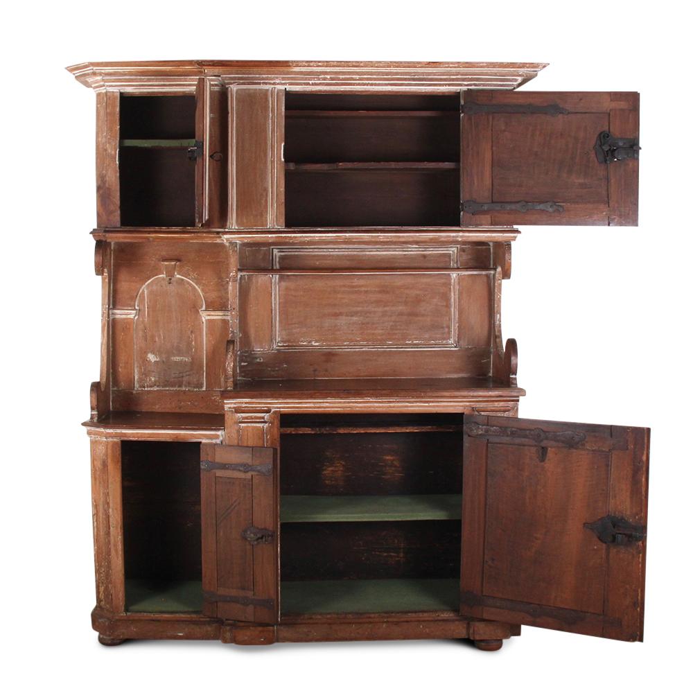 An unusual Early-to-Mid-19th century buffet hutch or kitchen cabinet of an asymmetrical design, the base with a large cupboard to the right and smaller to the left. These proportions are echoed in the upper cabinets, which are raised on boldly