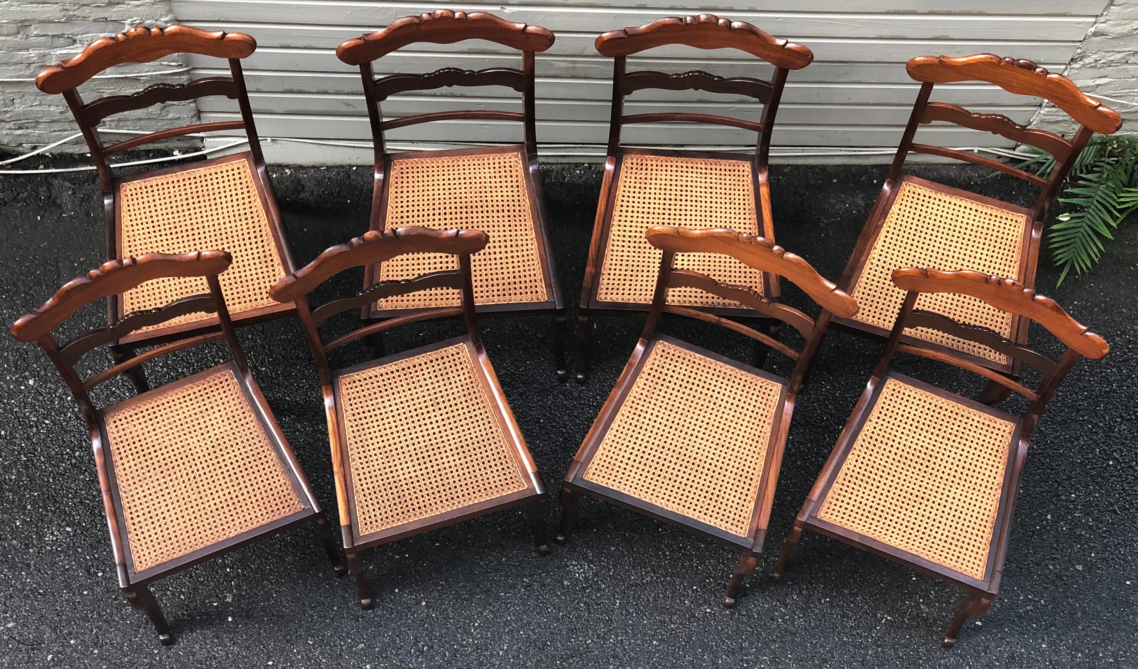 Wonderful set of eight rosewood Regency dining chairs with hand caned seats. These West Indies Regency chairs have a strong British Colonial influence, they are solid rosewood with high backs that are curved for back support and the caning for air