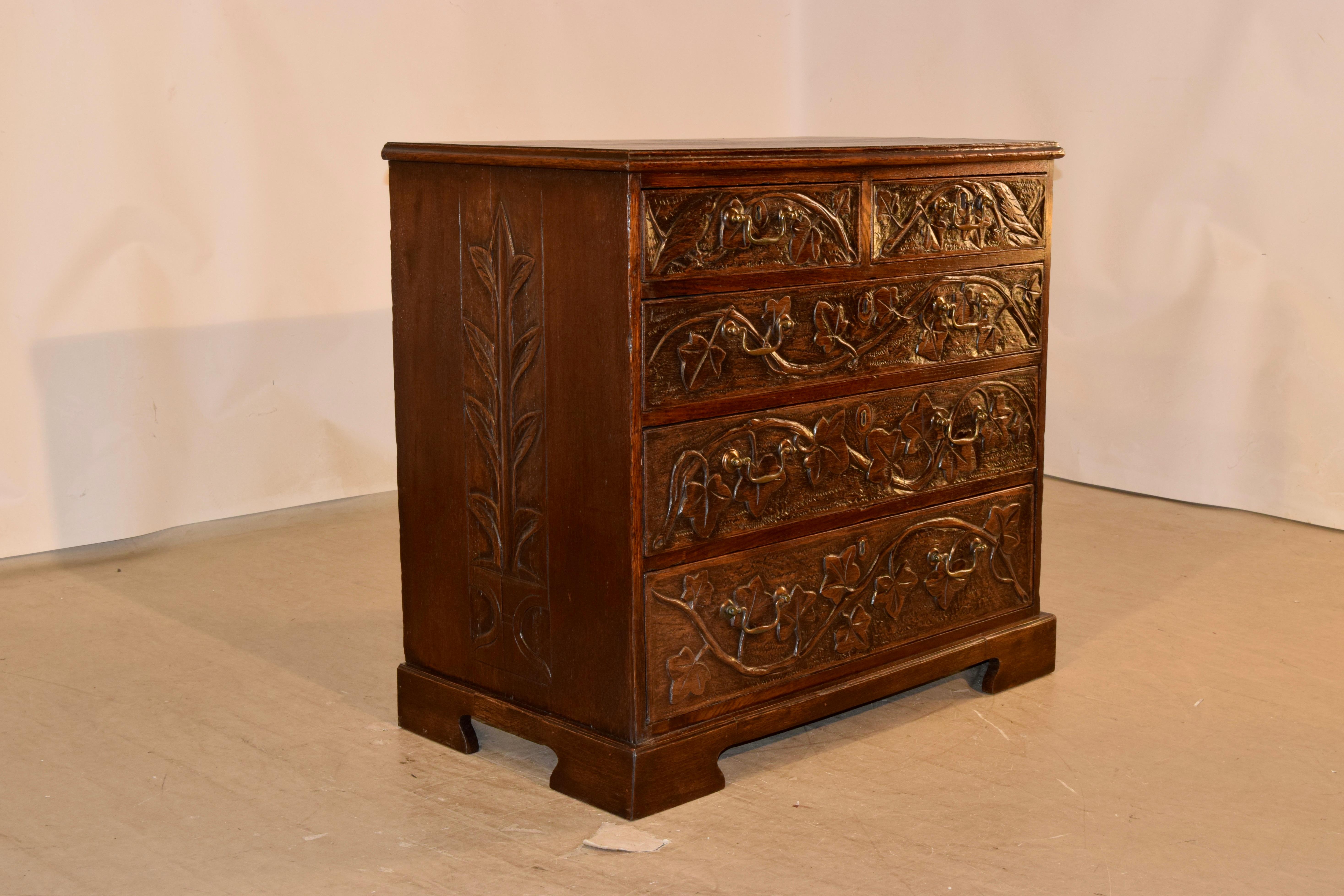 Circa 1800-1820 carved oak chest of drawers from England. The top has a lovely banded and beveled edge, over three board sides, with the center board decorated with hand carving of foliage on both sides. The front of the case has two over three