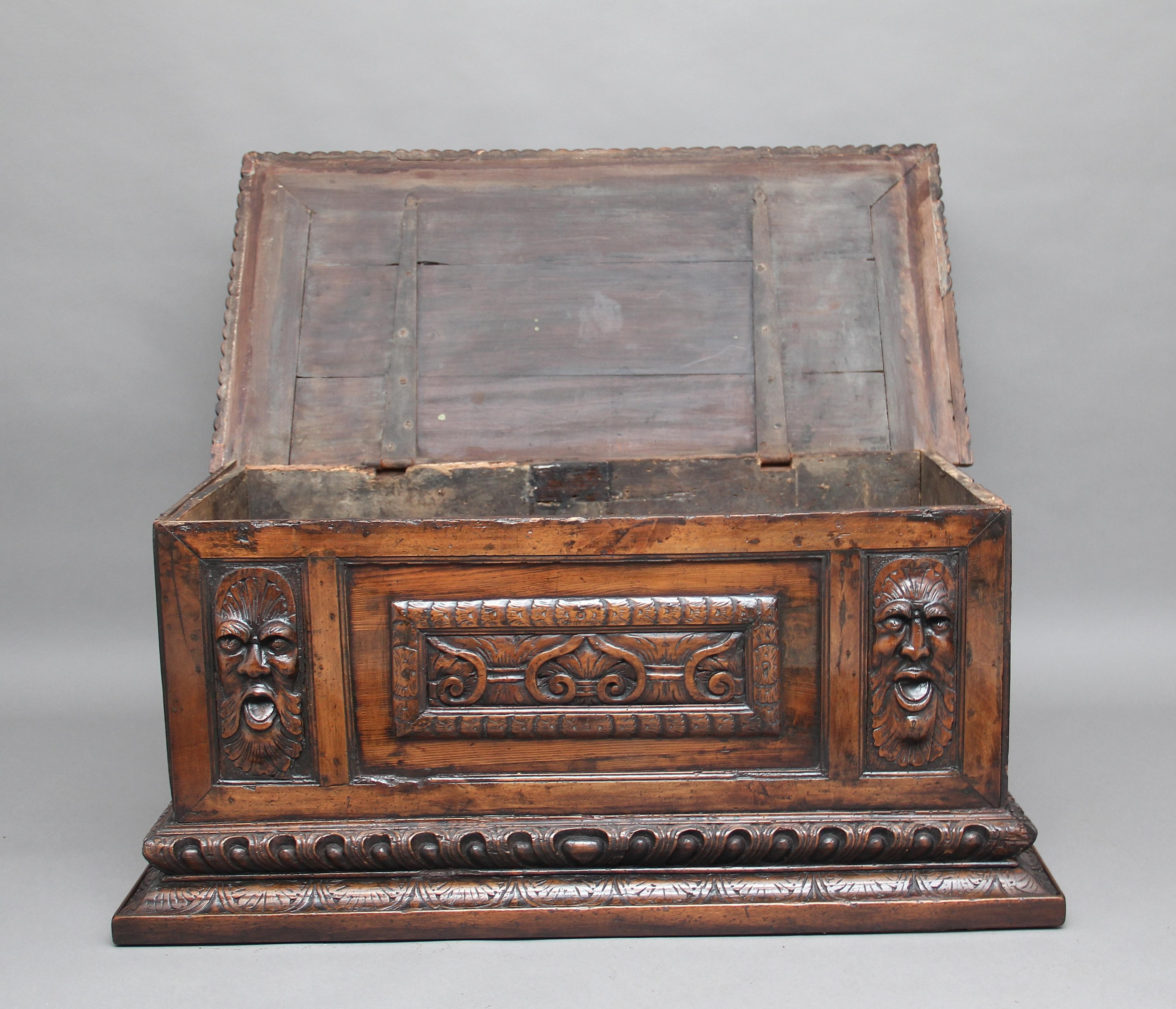Early 19th century carved fruitwood Italian coffer / cassone, with fabulous carved moldings around the base, having a pair of grotesque faces either side of a carved centre panel and carved panels on the sides, the lift up top having a gadrooned