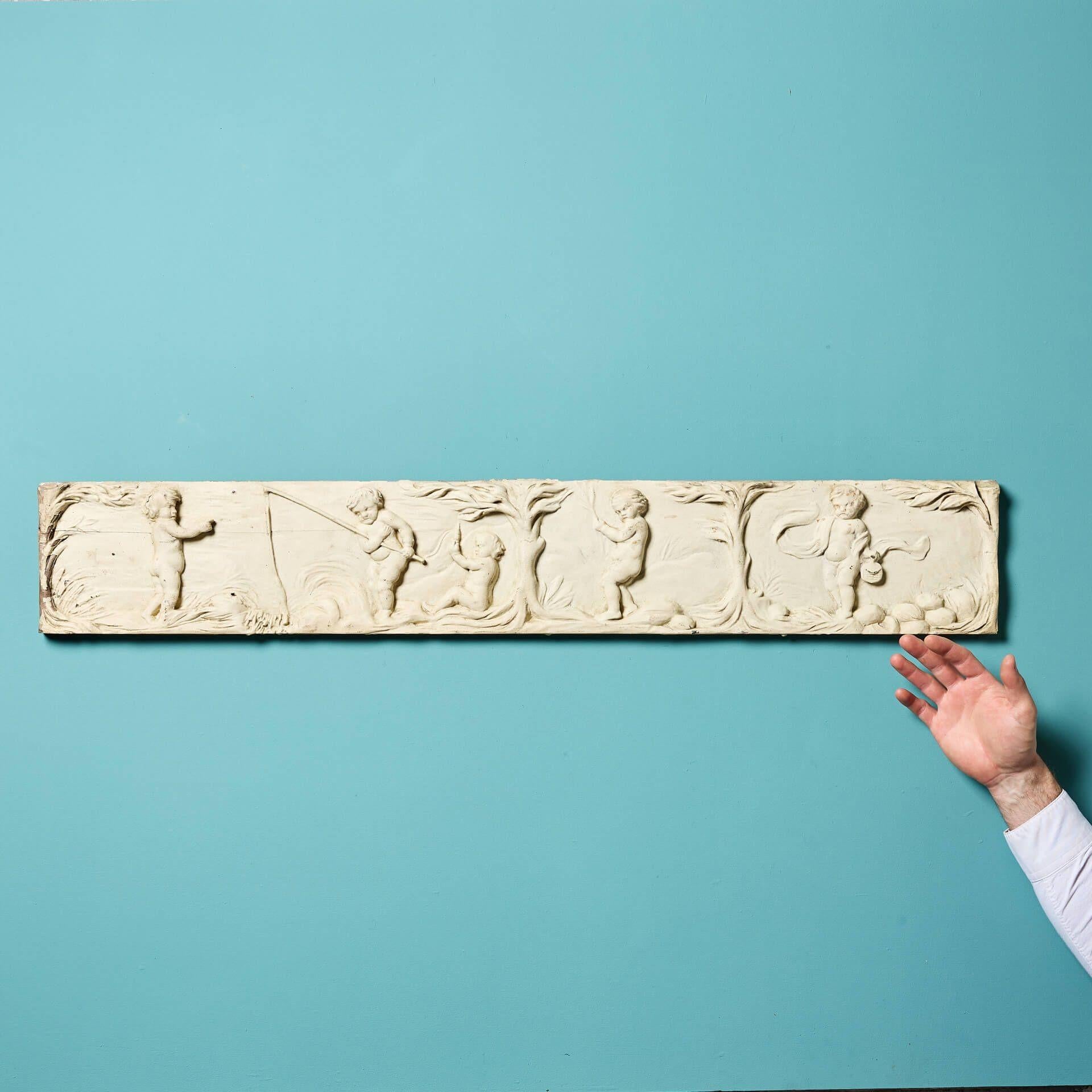 An early 19th century English carved limewood neoclassical frieze panel, circa 1800. This decorative wooden panel is over a metre long and features five putti or cherubs carved in the neoclassical style, carrying out various activities among trees.