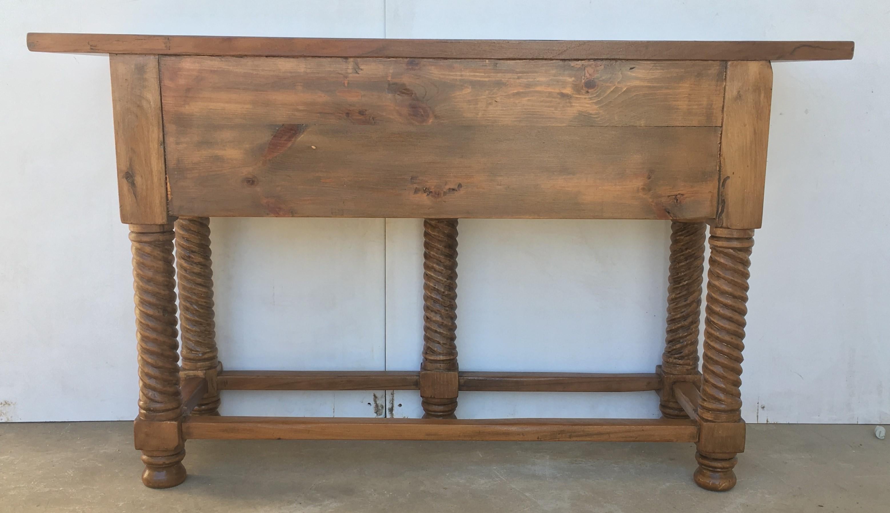 A 19th century walnut console table with a slab top above a frieze with two drawers with front decorated with carved geometrical motifs and incised with additional decoration and a single iron pull in each drawer. The table is supported on a