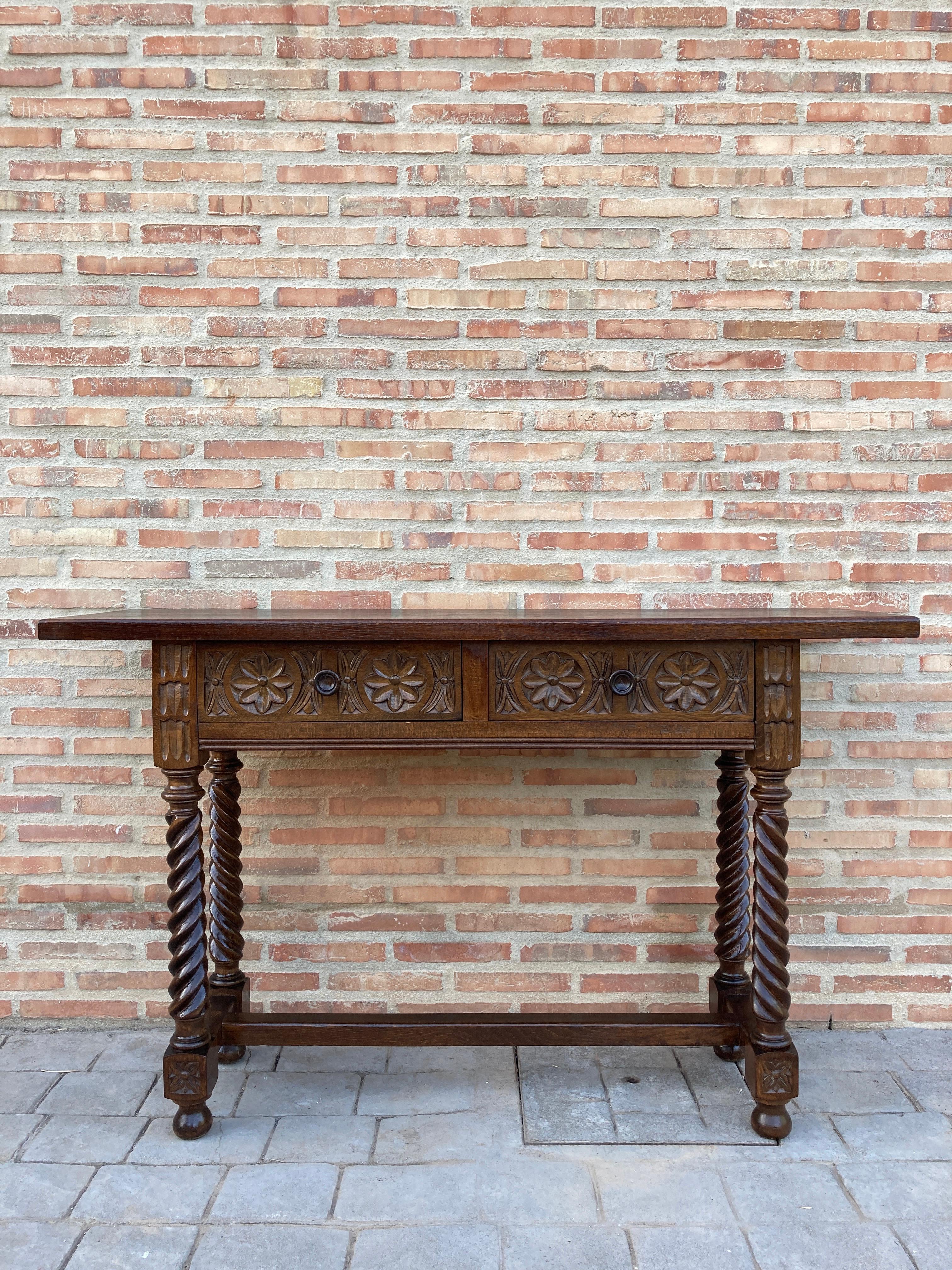 A 19th century walnut console table with a slab top above a frieze with three drawers with front decorated with carved geometrical motifs and incised with additional decoration and a single original iron pull in each drawer. The table is supported