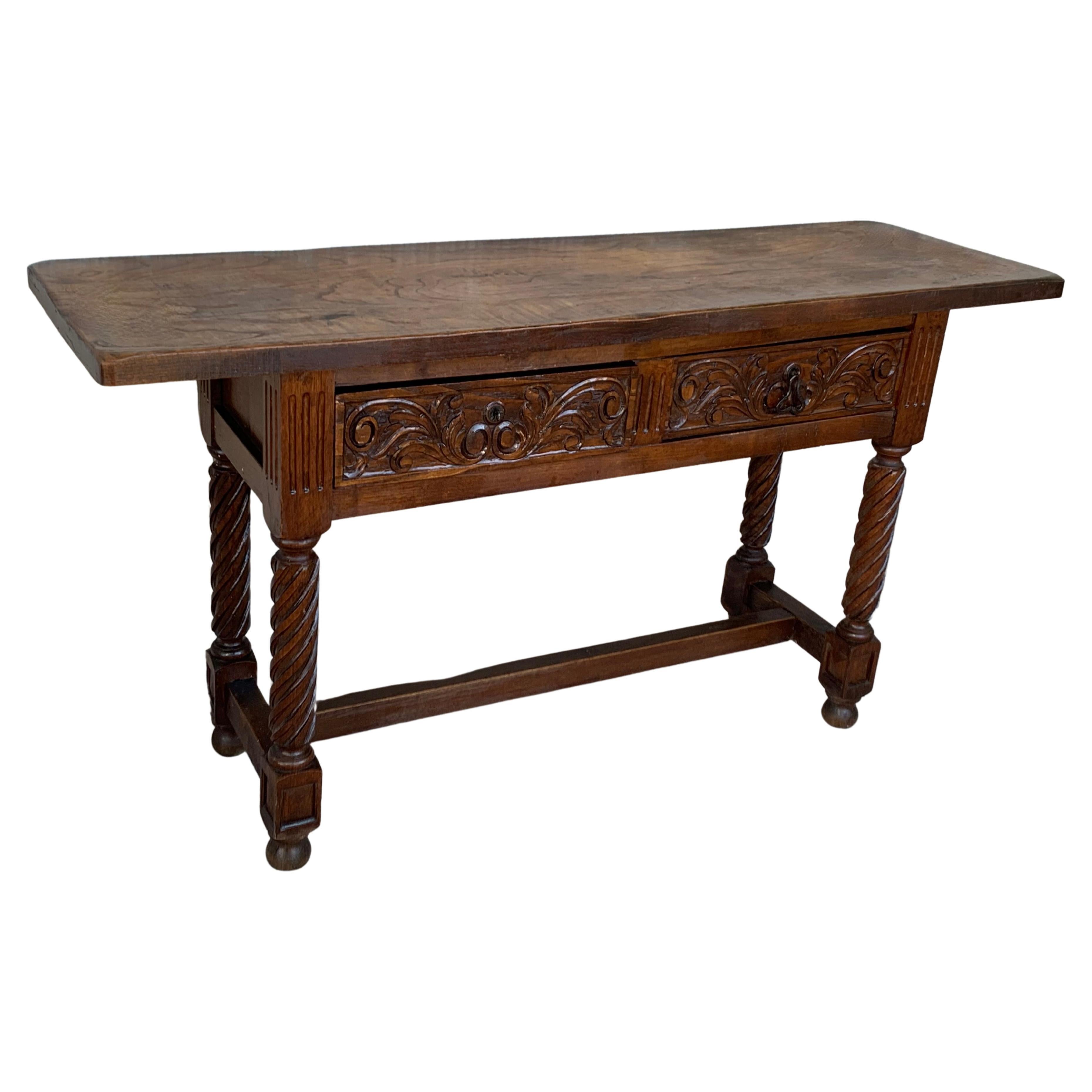 A 19th century walnut console table with a slab top above a frieze with two drawers with front decorated with carved floral motifs and incised with additional decoration and a single original iron pull in each drawer. The table is supported on a